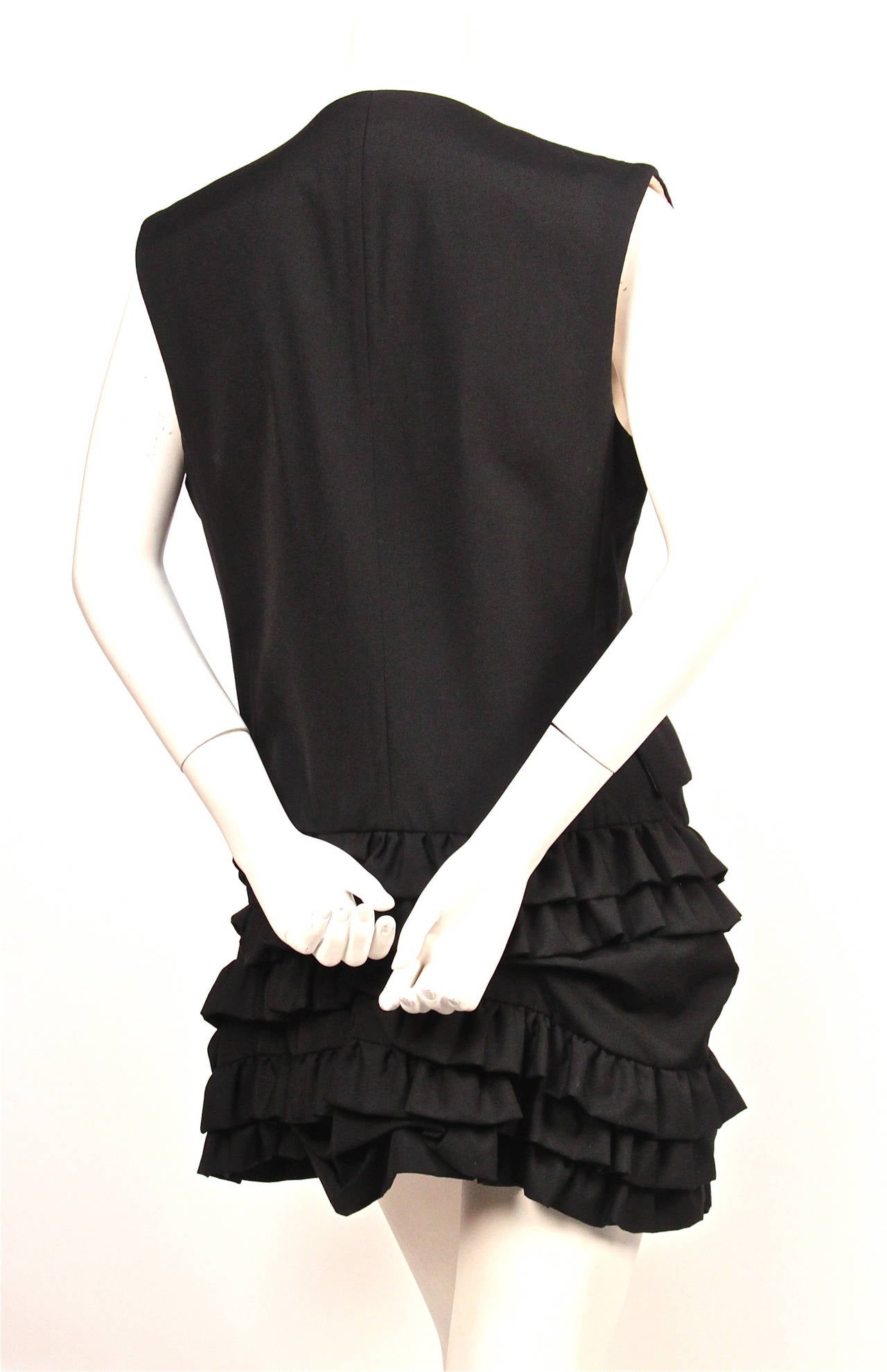 Jet black wool gabardine 'menswear' dress with ruffled skirting from Comme Des Garcons dating to 1994. Size 'S'. Approximate measurements: shoulder 15