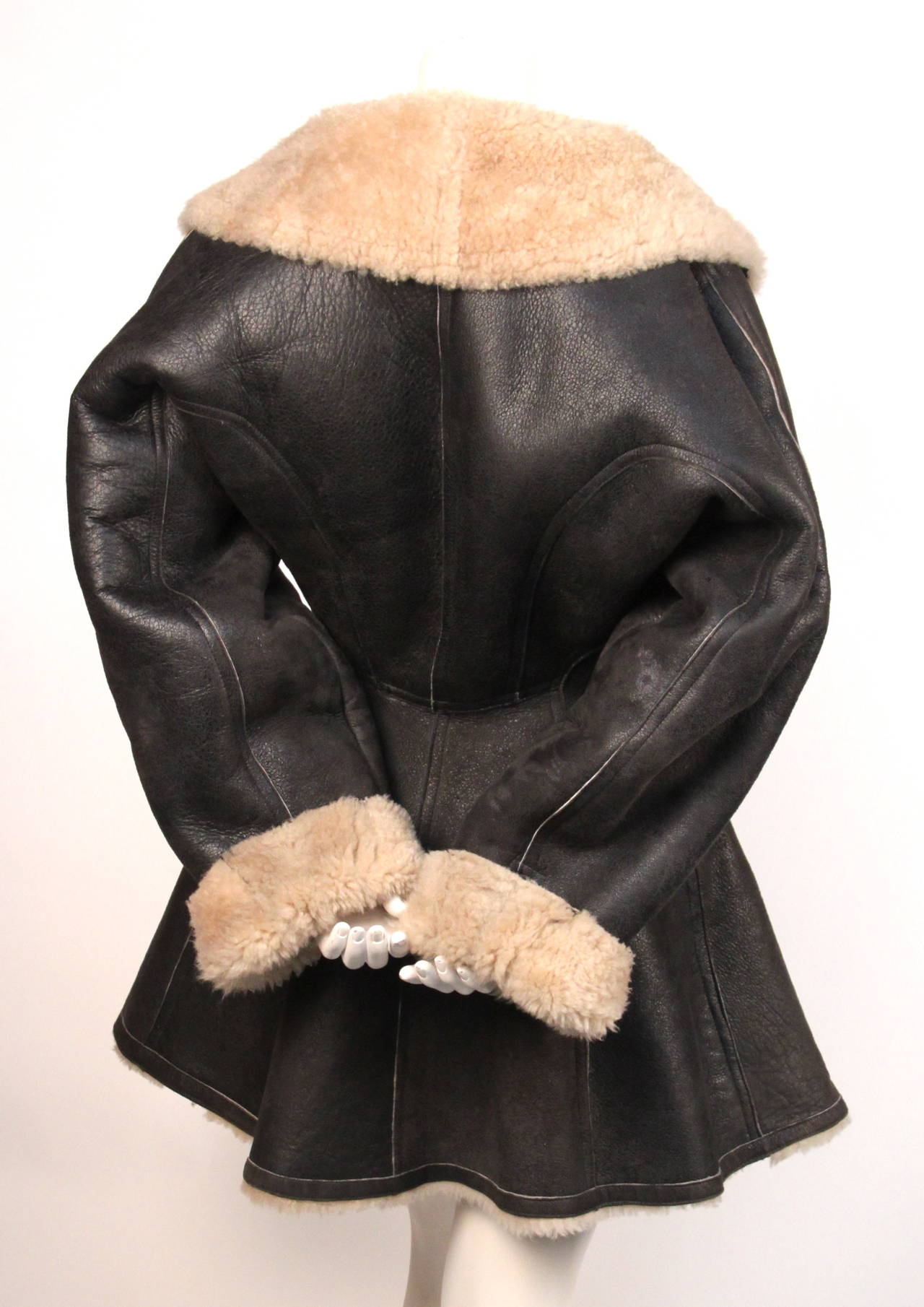 Brown shearling coat with flared hem designed by Azzedine Alaia dating to 1987. Coat is labeled a French size 38.  Zip closure. Pockets at hips. Made in France. Very good condition.