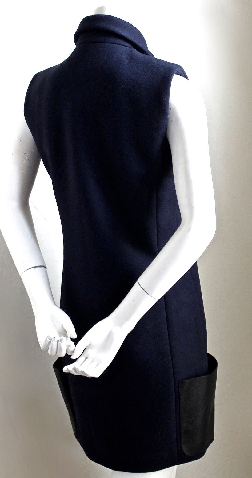 Navy blue wool dress with large leather patch pockets designed by Phoebe Philo for Celine as seen on the runway for fall 2010. Piece can be worn as a dress or a sleeveless jacket. Labeled a French size 38. Approximate measurements: 34