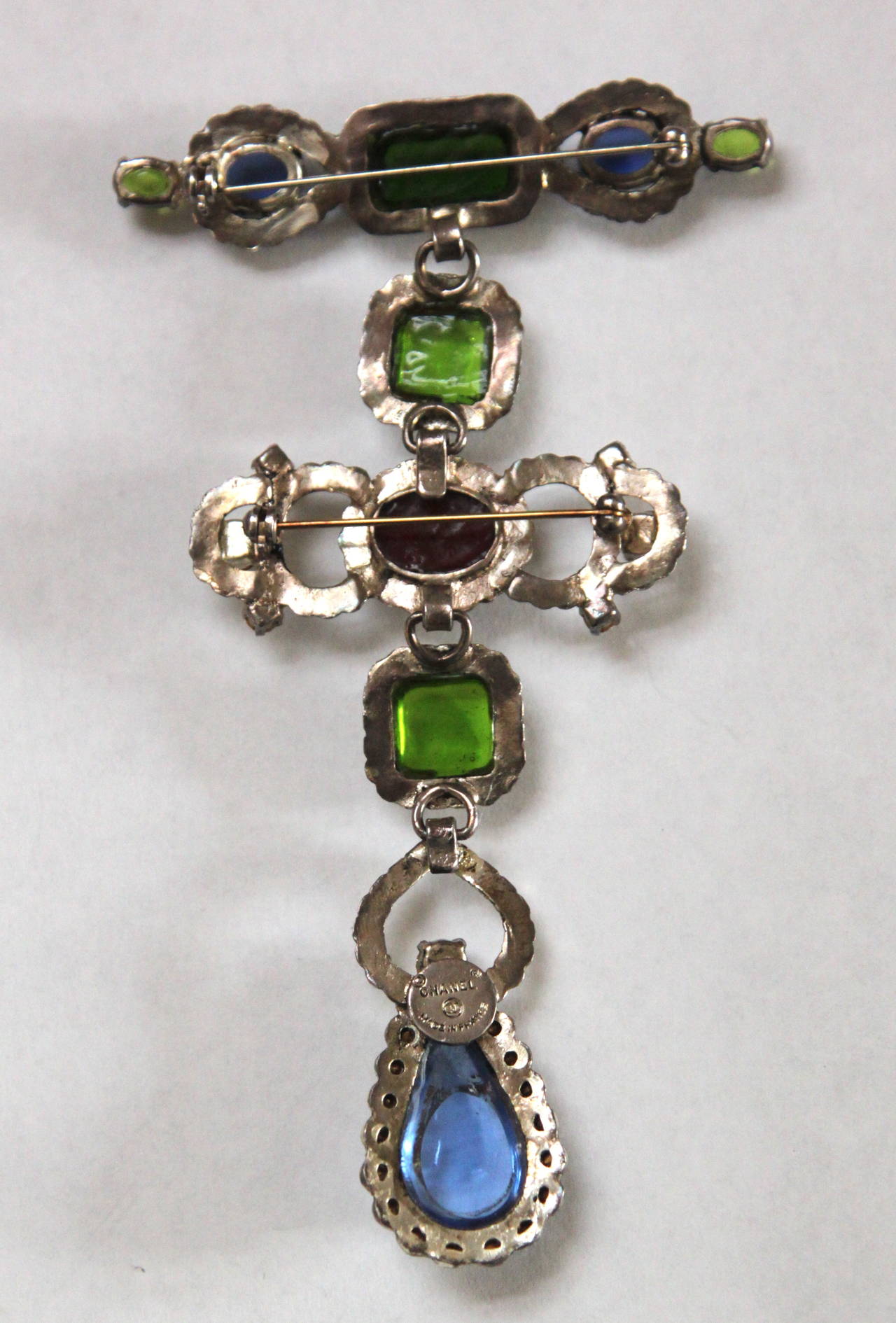 Very rare documented interchangeable rhinestone pendant/brooch with Gripoix poured glass from Chanel dating to the 1970's. Silver toned metal, clear rhinestones, and burgundy, green and blue poured glass. Piece can be worn numerous ways: it can be