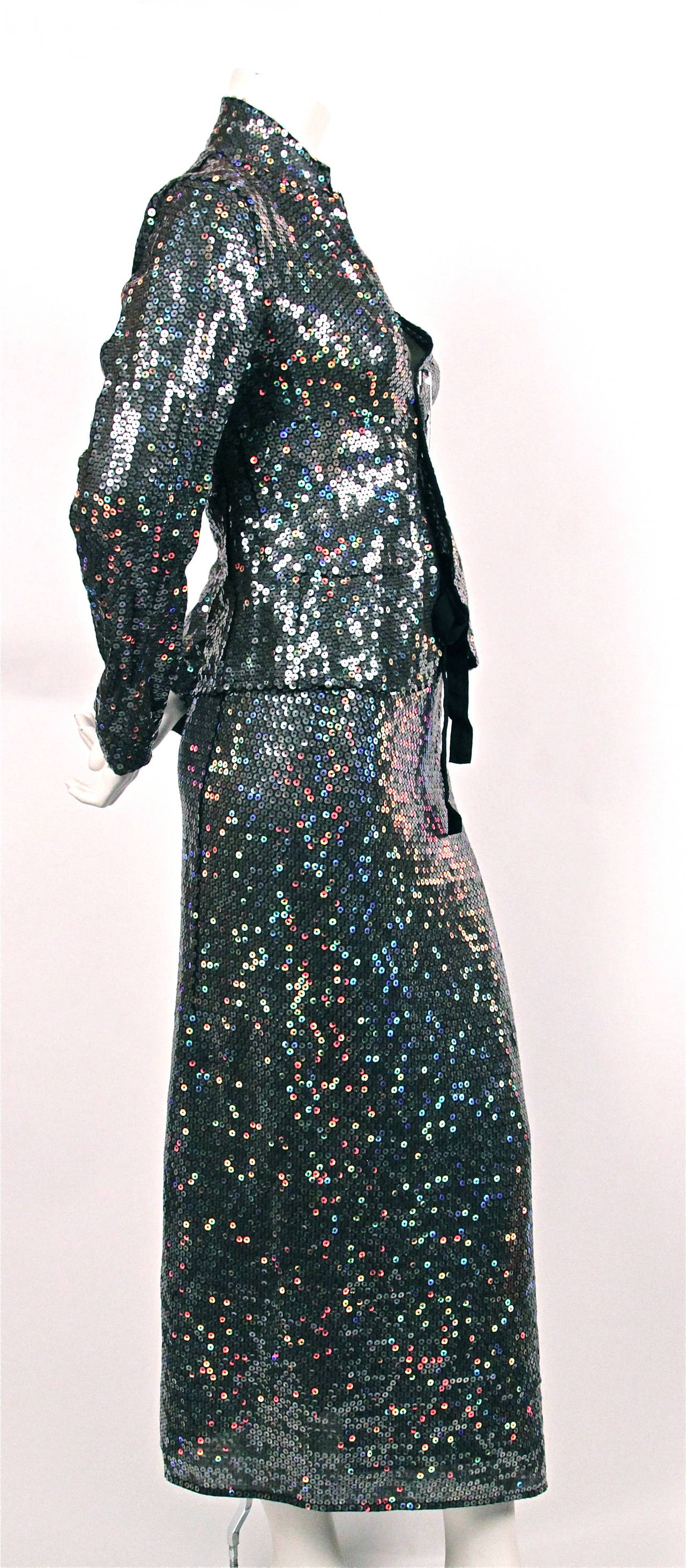 Colorful sequined black jacket with oversized safety pin closure paired with matching wrap skirt from Comme Des Garcons dating to 1999. No size is indicated although this would best fit a size XS or S. Due to wrap skirt design the skirt sizing is