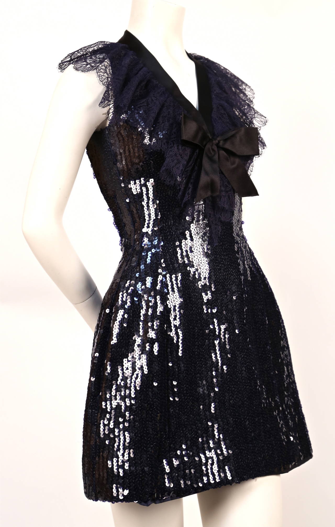 Very rare navy blue sequined mini dress with chantilly lace collar and black satin bow from designed by Karl Lagerfeld for Chanel dating to 1987. French size 34 which best fits a US 2. Approximate measurements: bust 30