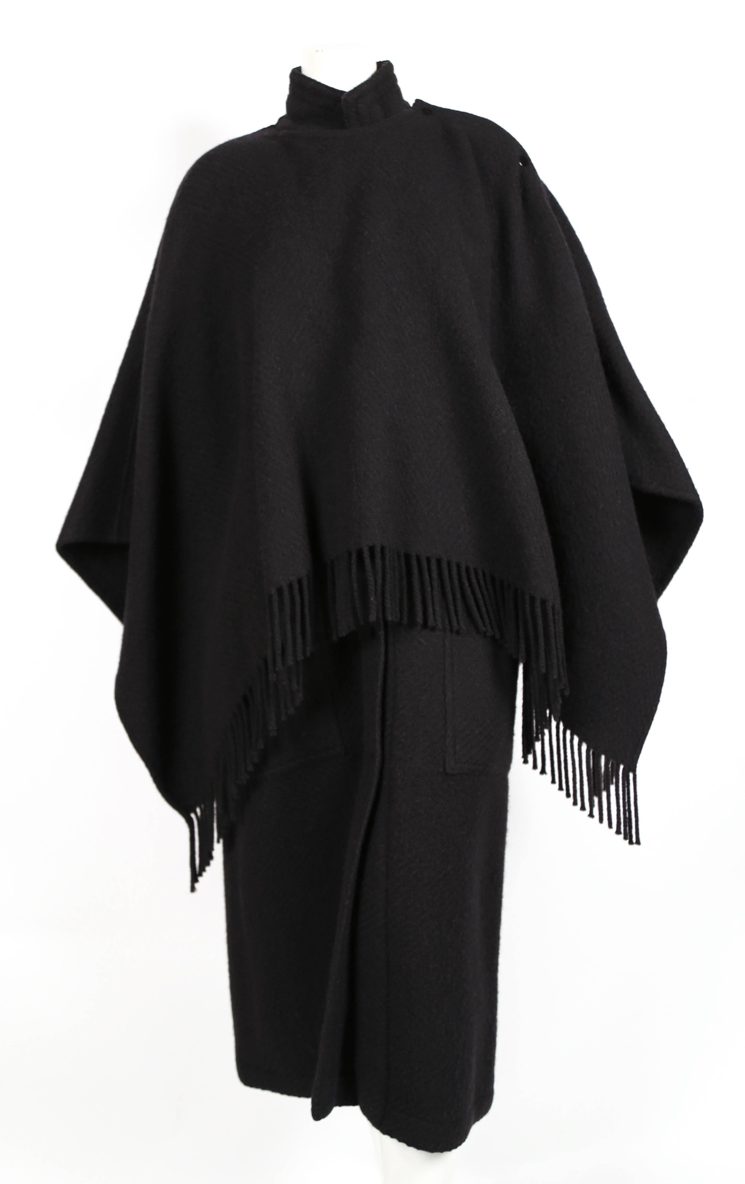 Heavy black wool coat with fringed cape from Jean-Charles de Castelbajac dating to the 1980's. Fits a US 4-8. Approximate measurements: drop shoulder 23