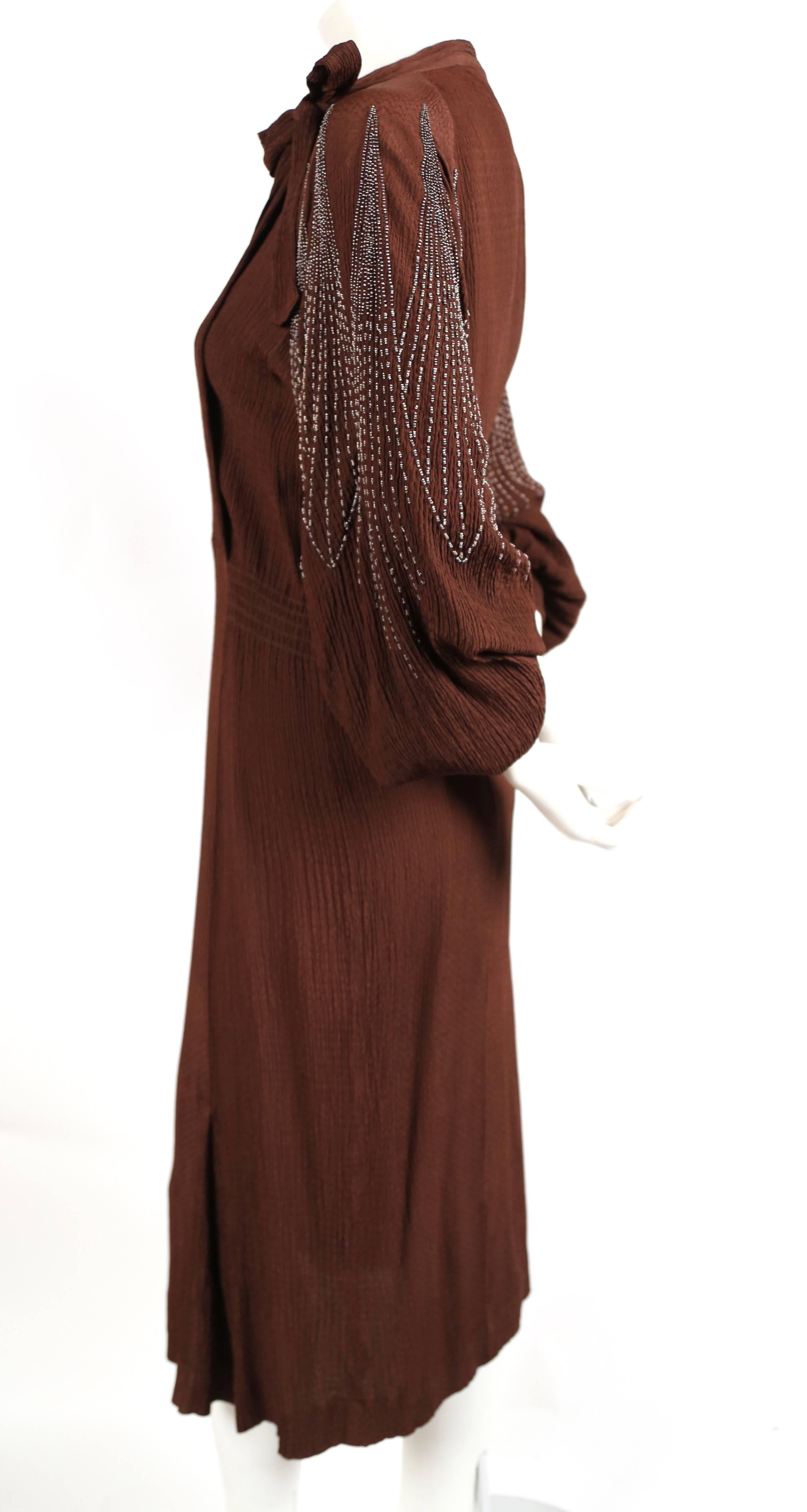 Rich brown crepe dress with heavily beaded sleeves from Mainbocher dating to the late 1930's. This is a very rare piece from the Parisian atelier before Mainbocher relocated to New York.  Dress best fits a US size 8-10. Dress measures approximately: