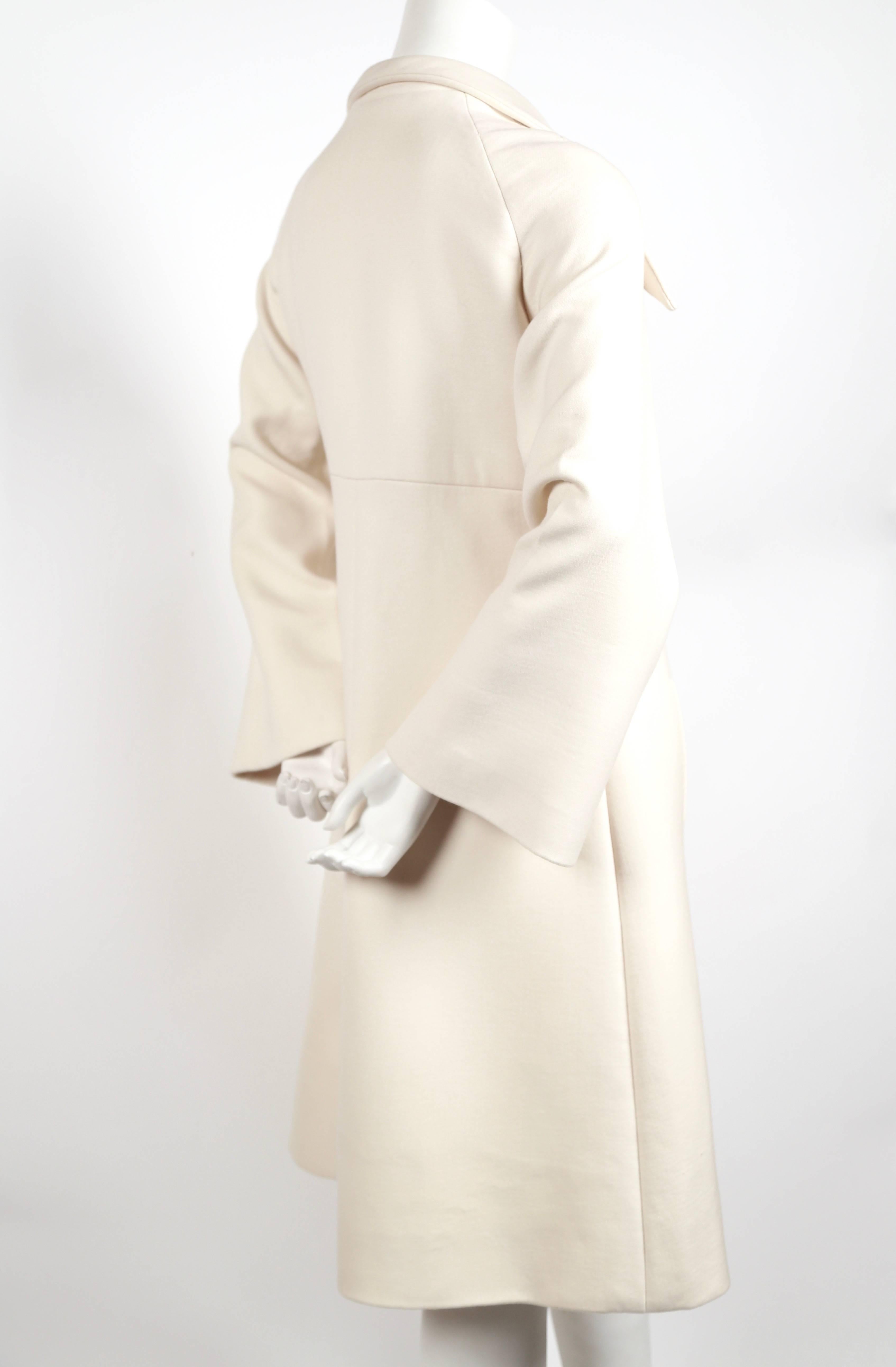 Cream wool haute couture coat with large collar and wide sleeves designed by Pierre Cardin dating to the 1970's. Best fits a US 2-6 (coat was not clipped on a size 2 mannequin). Approximate measurements: bust 36