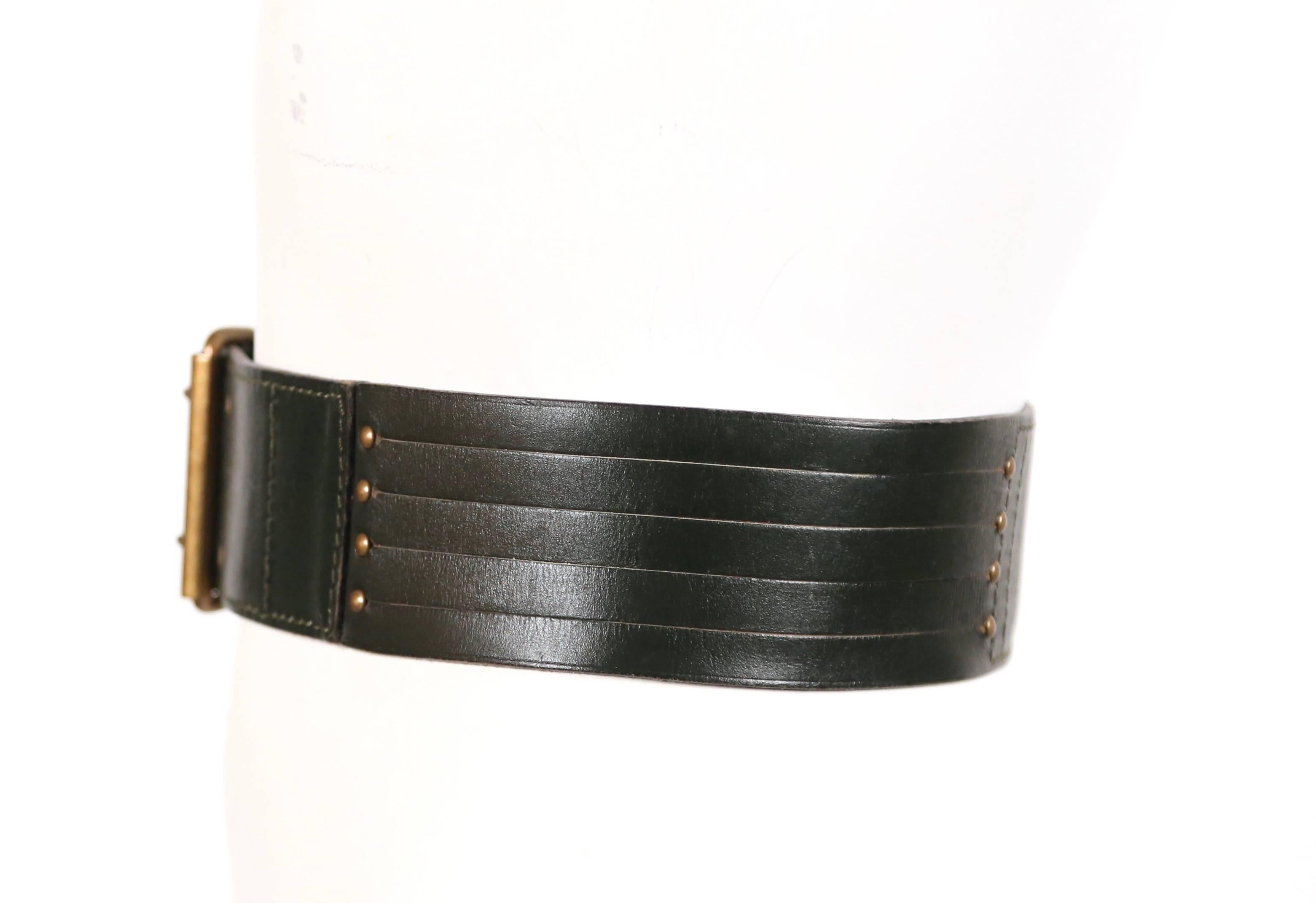 Darkest green leather belt with brass hardware designed by Azzedine Alaia dating to the 1990's. French size 70. Holes fall at approximately:  26