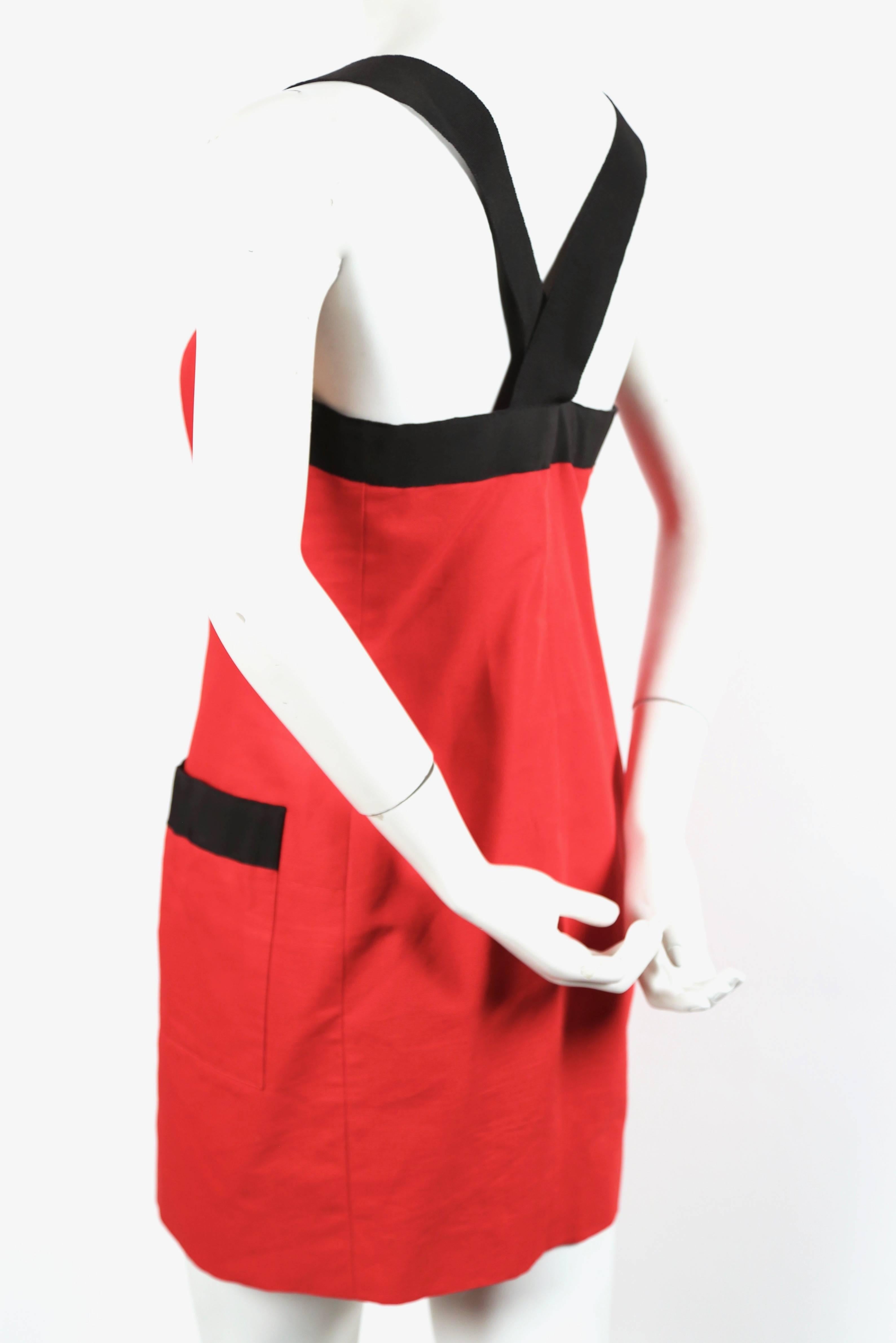Red mini dress with wide black grosgrain ribbon trim by Yves Saint dating to the 1990's. 
Labeled a French size 40. Dress measures approximately: 18” at bust,  16” at waist and at the hips 18”. Button front closure. Fabric content: 100% cotton. Made