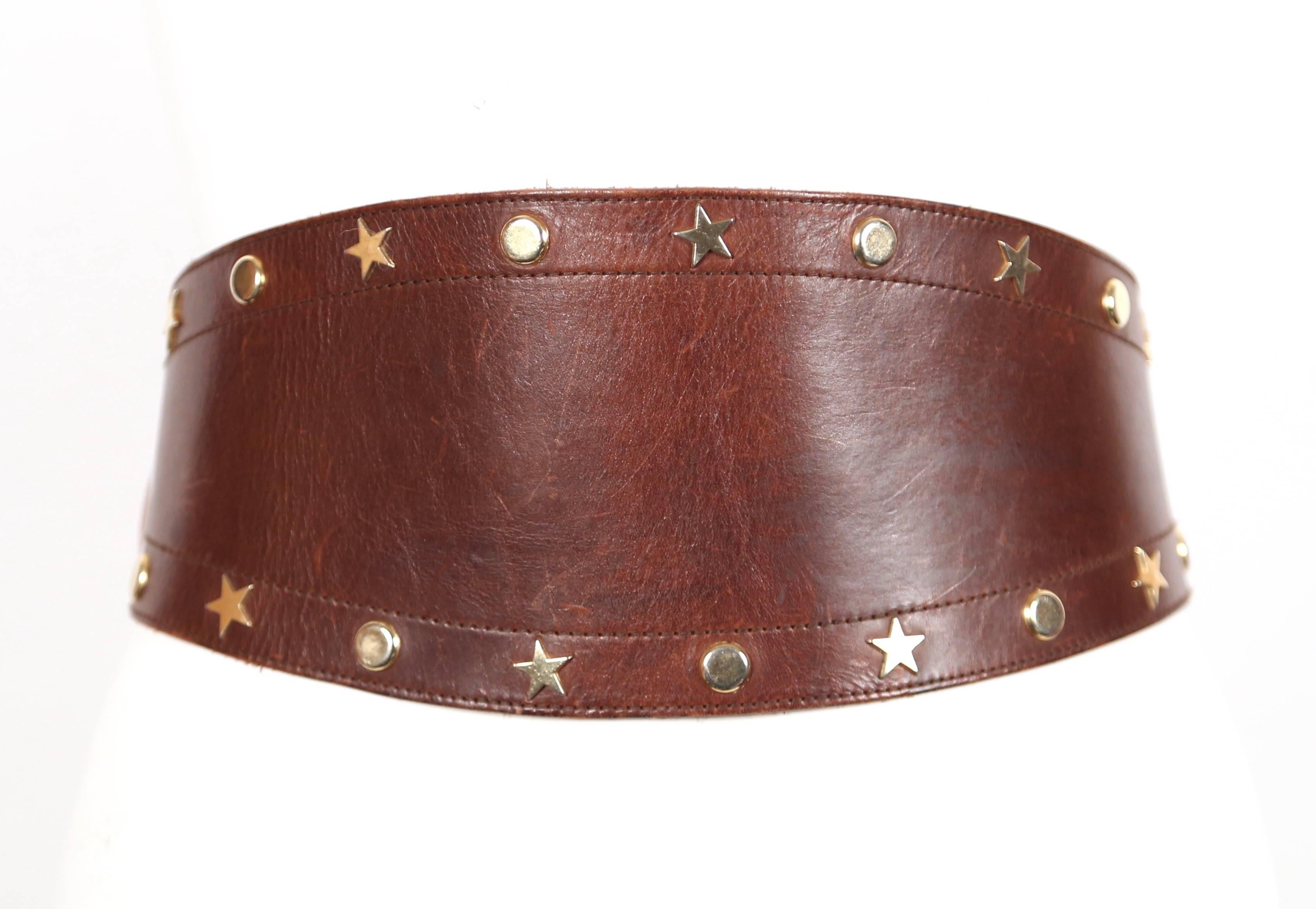 Ceinture en cuir brun riche avec étoile dorée et clous circulaires avec une belle patine datant des années 1980. Mesures approximatives : les trous tombent à 26,5