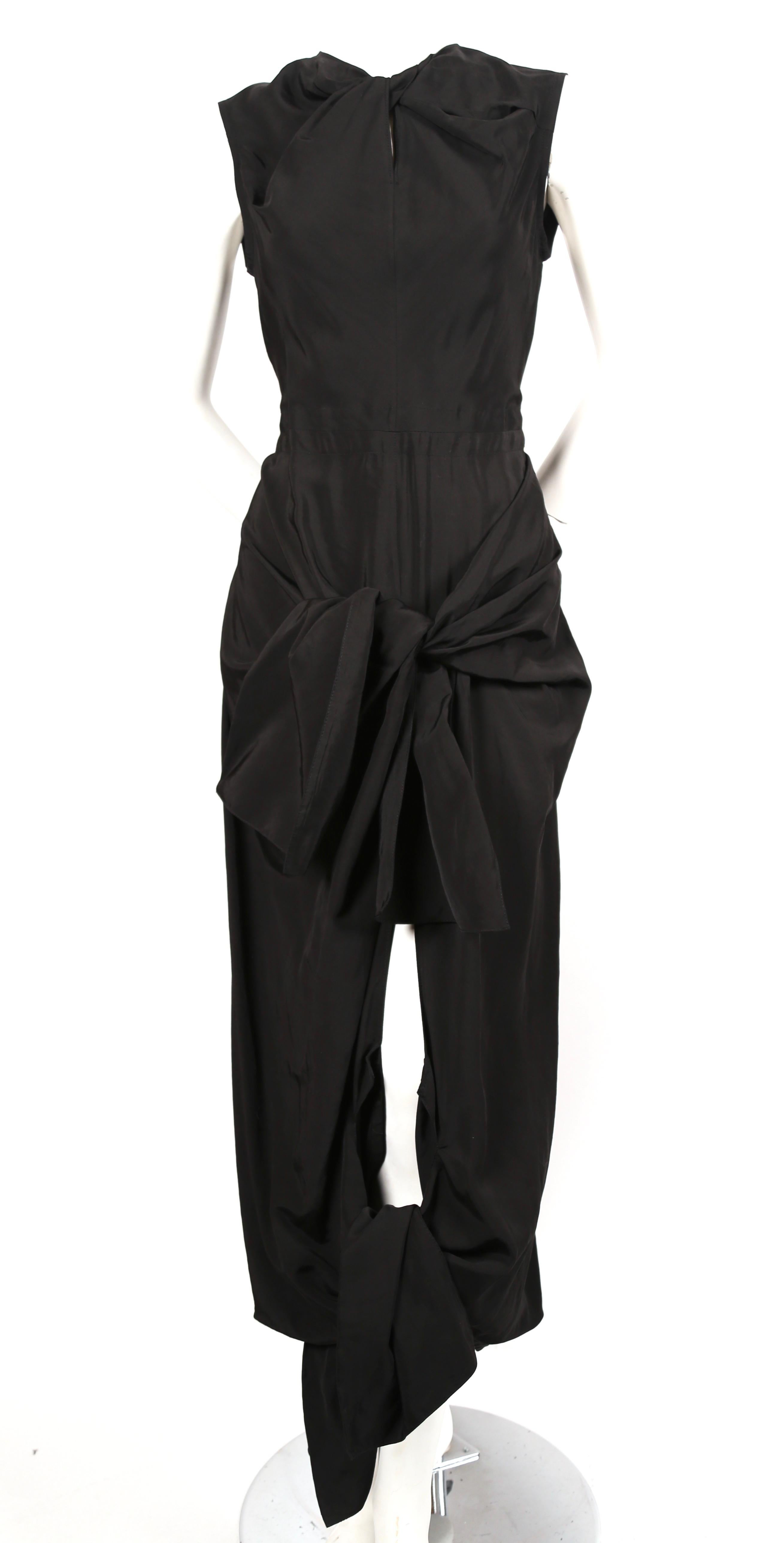 Jet black dress with twisted neckline, ties at hips and cut out at back designed by Phoebe Philo for Celine. French size 38. Approximate measurements: shoulder 14