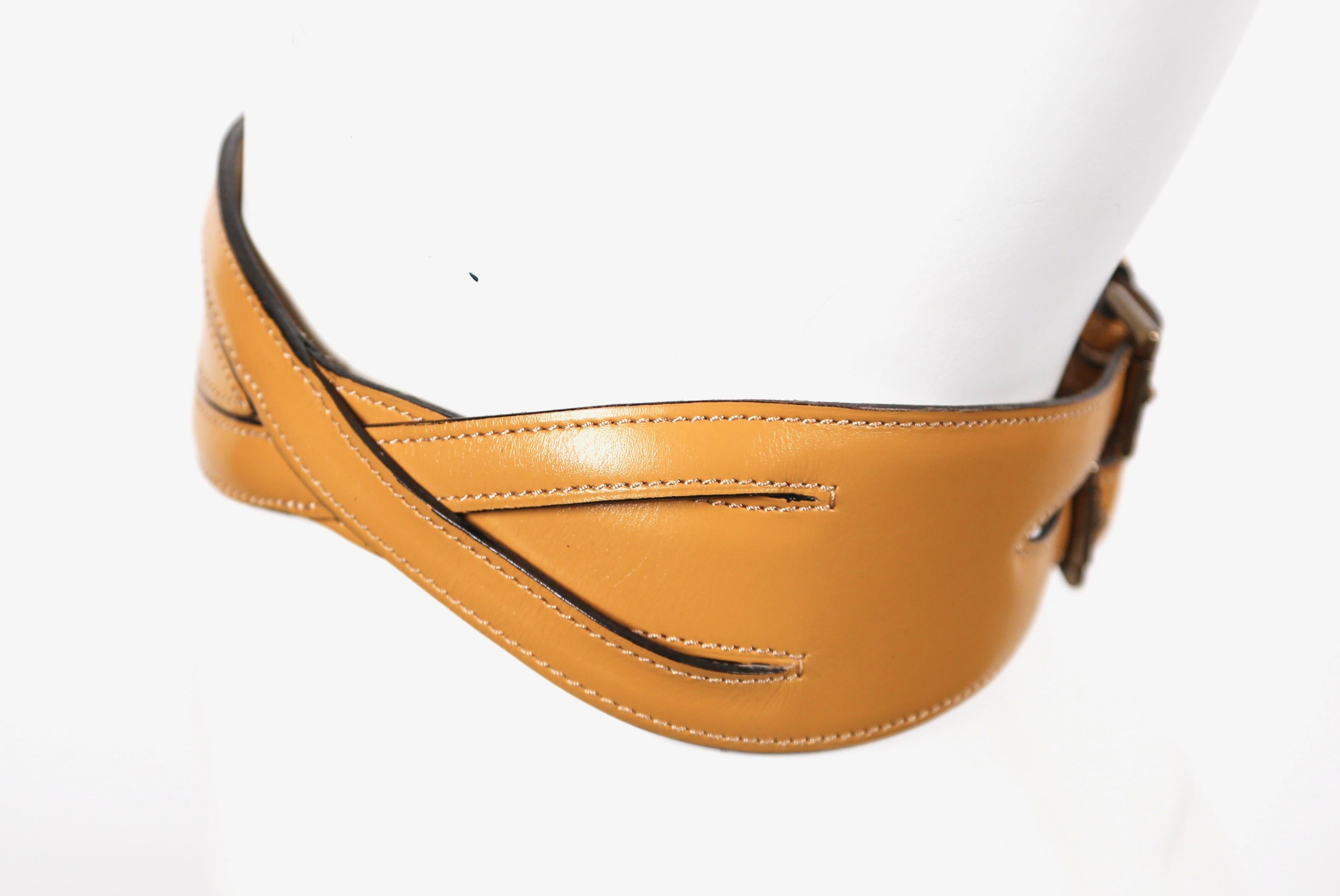 Rich tan leather belt with brass hardware designed by Azzedine Alaia dating to fall of 1990 as seen on the runway. Labeled a French size 65. Fits a 24-26