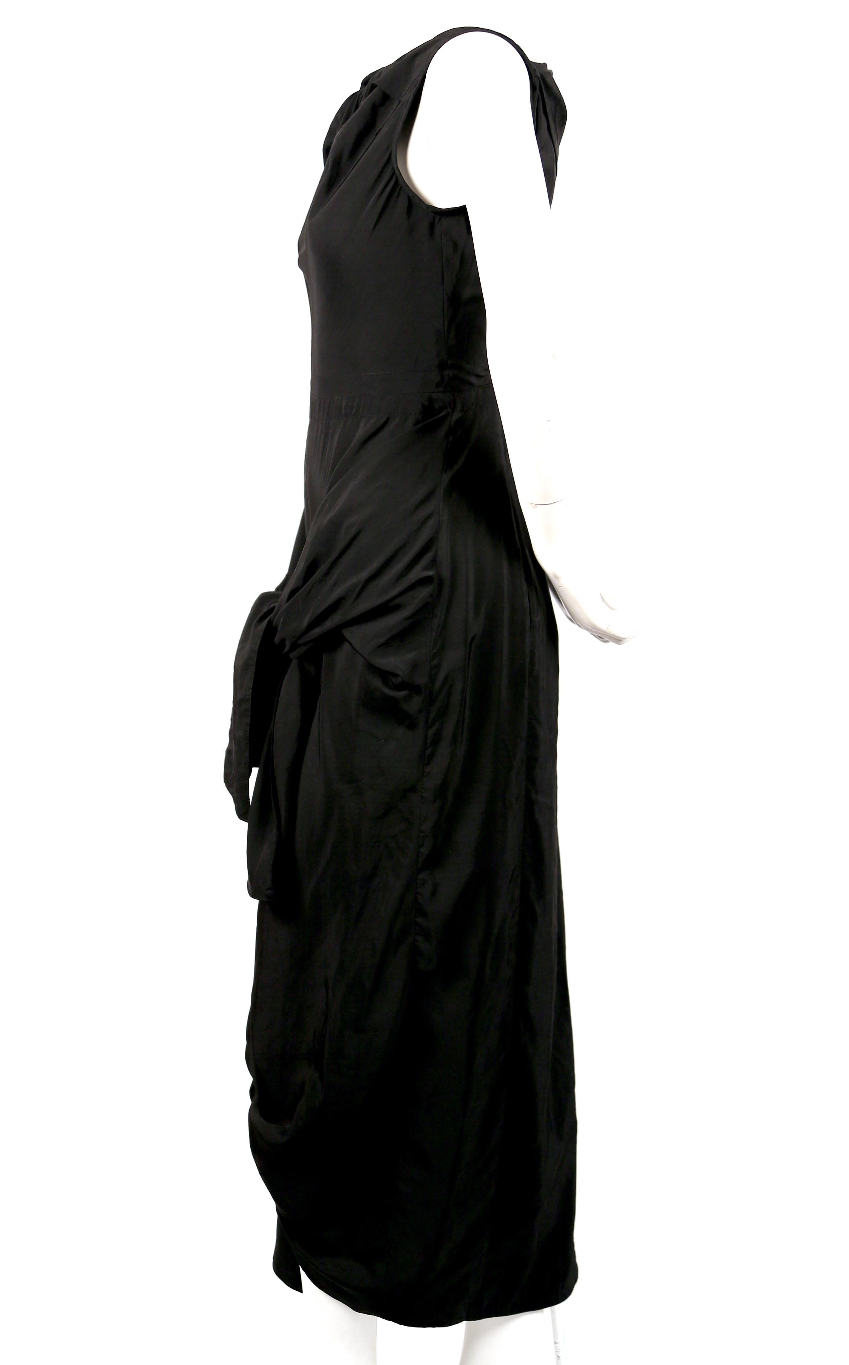 Jet black dress with twisted neckline, ties at hips and cut out at back designed by Phoebe Philo for Celine. French size 34. Approximate measurements: shoulder 13