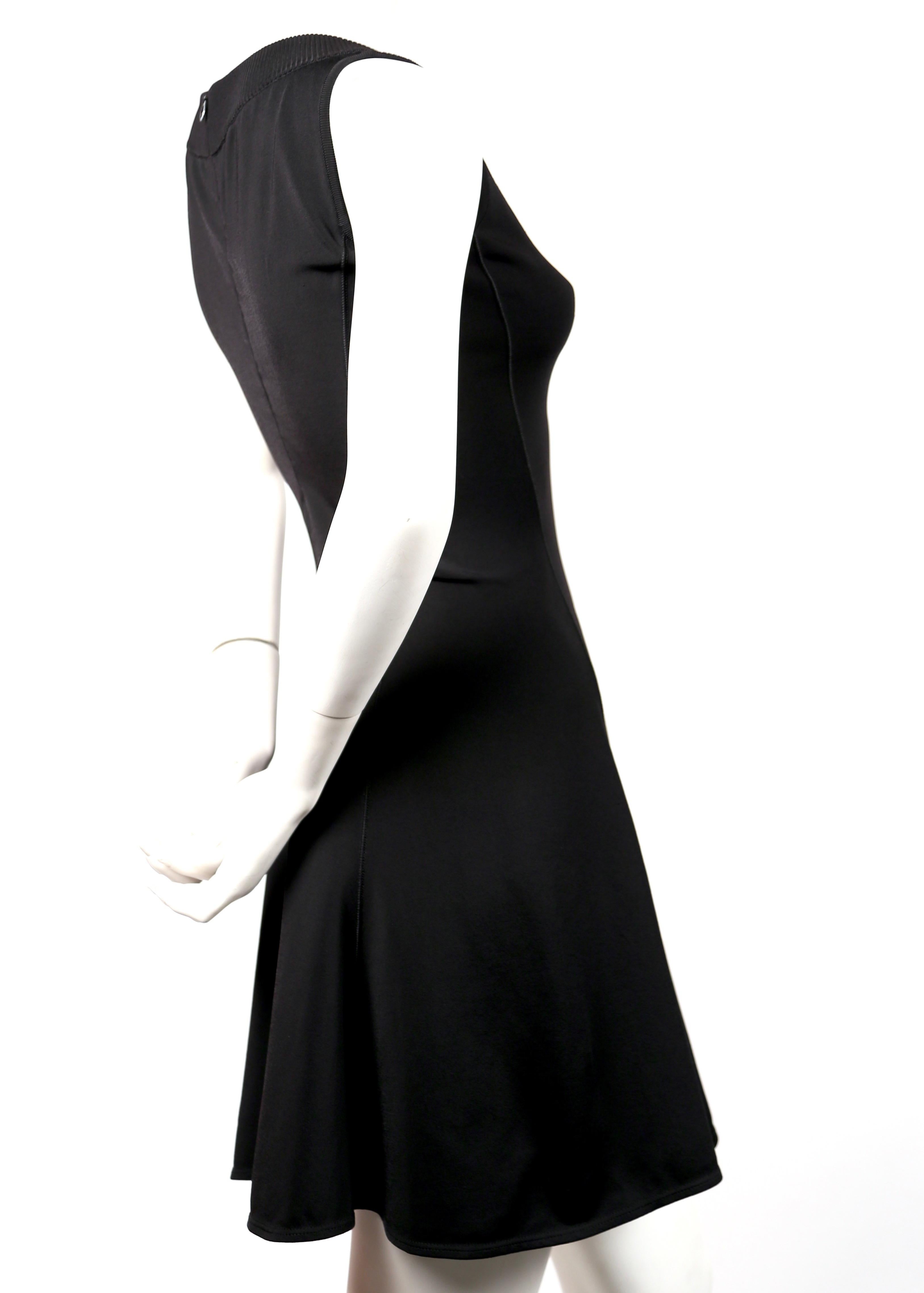 Jet-black, flared, sleeveless dress with V neckline designed by Azzedine Alaia dating to the early 1990's. Size S. Approximate measurements (unstretched): bust 31-32