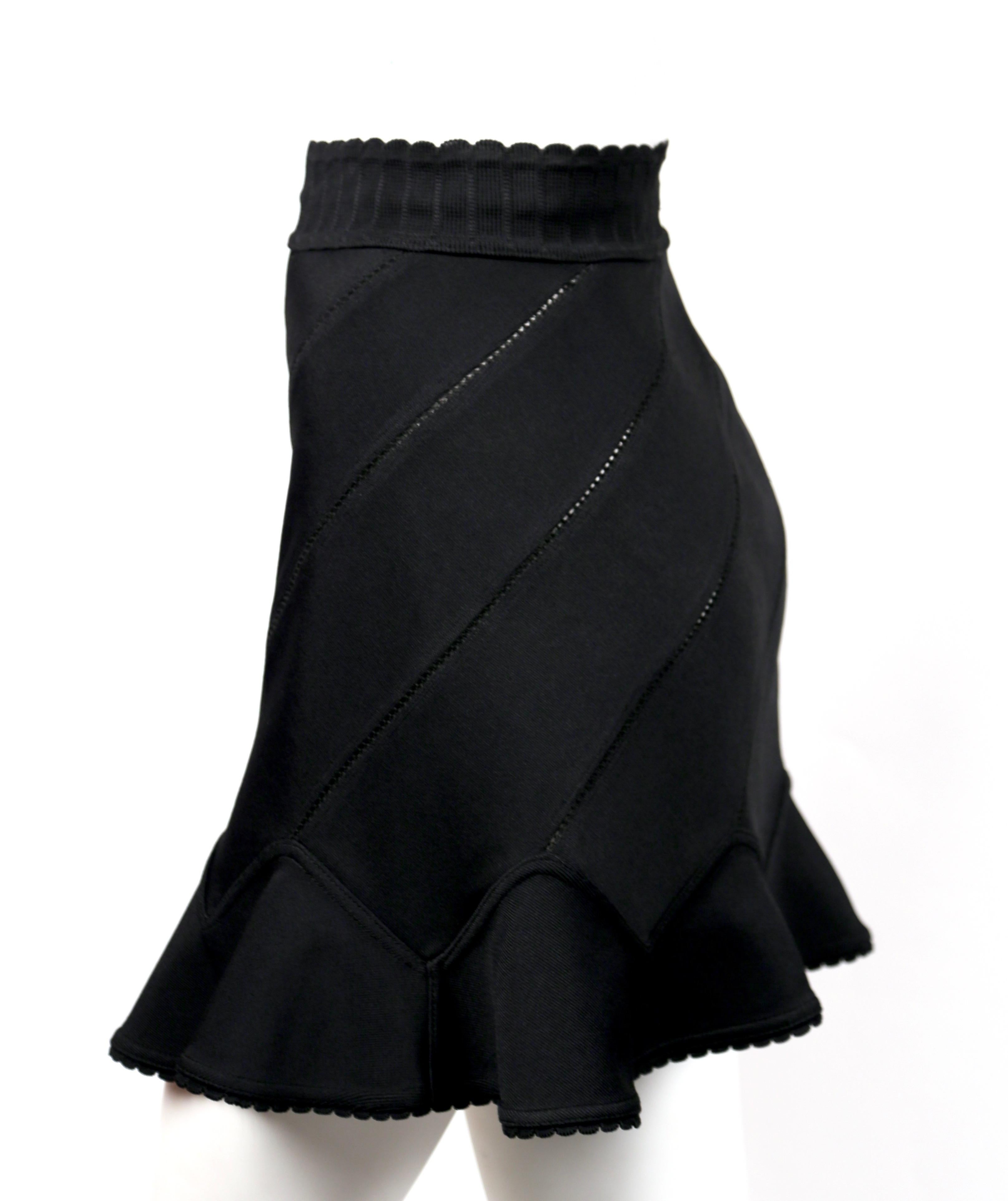 Jet-black, pointelle-knit skirt with spiral seams and flounced hem designed by Azzedine Alaia dating to spring of 1992.  Best fits a size XS or S. Approximate measurements (unstretched): waist 23