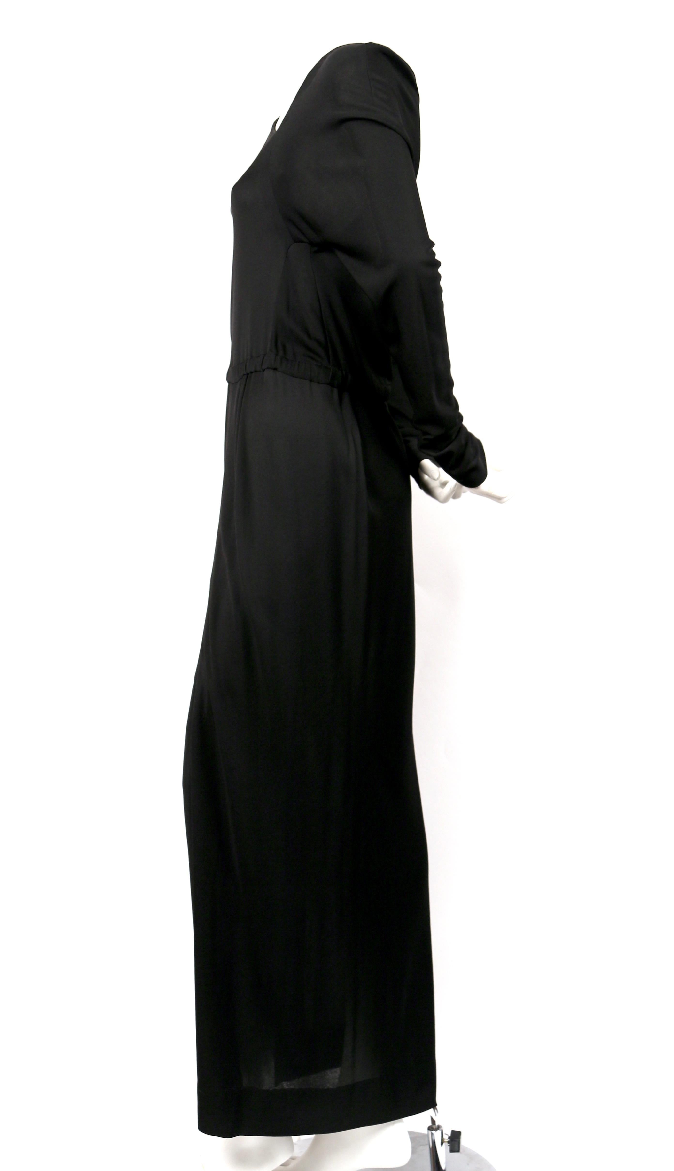 Jet-black, silk jersey gown with asymmetrical cut designed by Halston dating to the 1970's. No size is indicated however this would best fit a US 4-6. Approximate measurements: bust 33-34