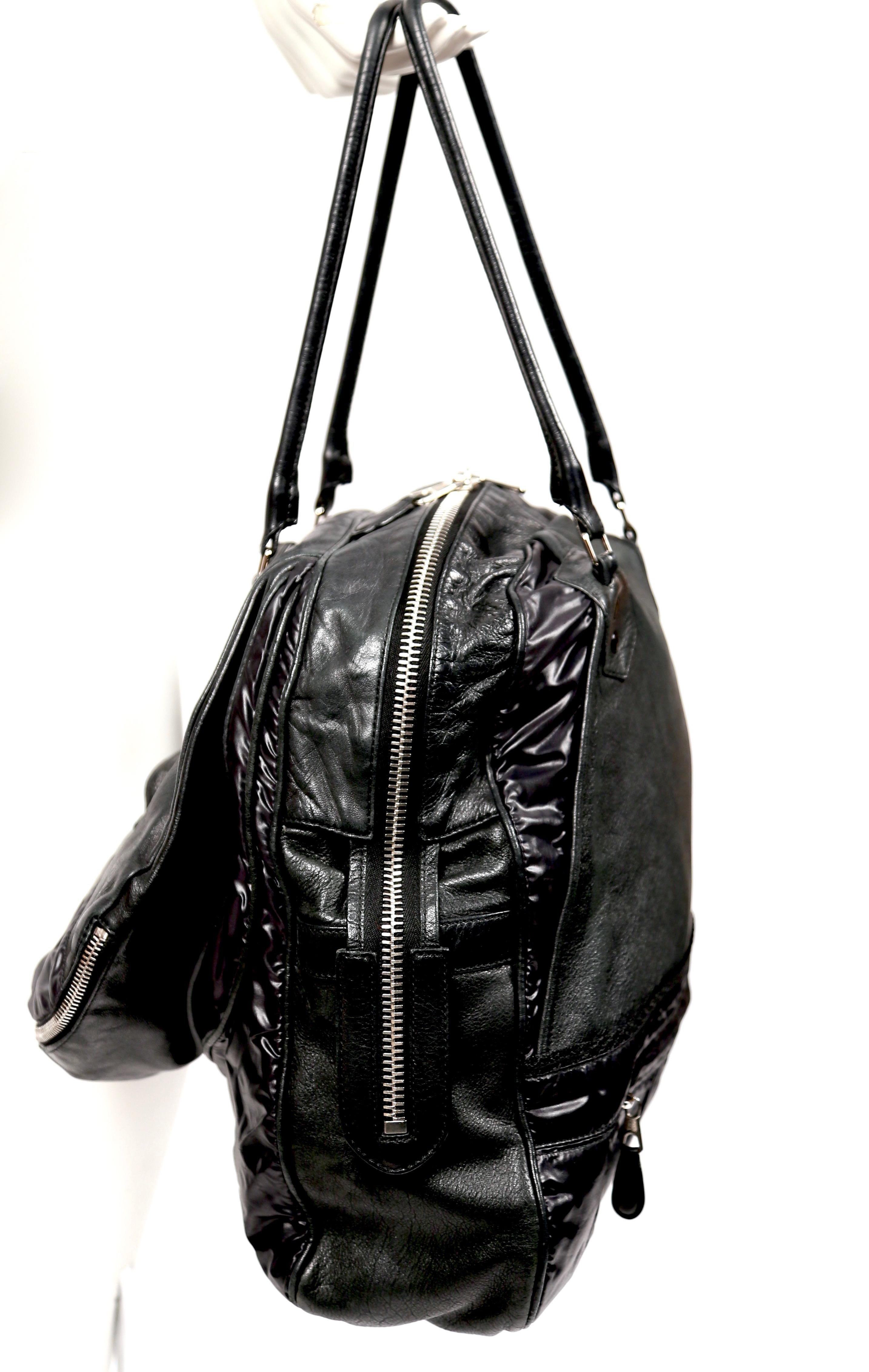 Very rare, black parachute bag with chevre leather and nylon insets designed by Nicolas Ghesquiere for Balenciaga dating to 2003. Bag features silver-toned hardware, two rolled shoulder straps, single exterior compartment with interior zip pocket,