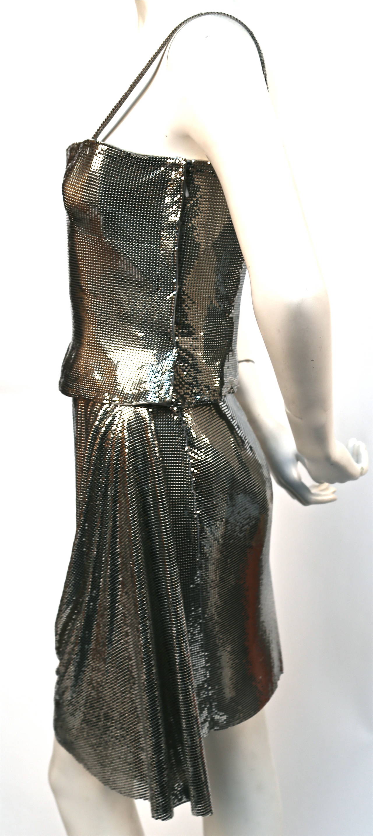 Very rare silver Oroton chain mail draped skirt with matching fitted top from Gianni Versace Couture dating to 1994. Skirt Labeled an Italian size 40. Approximate measurements: waist 25