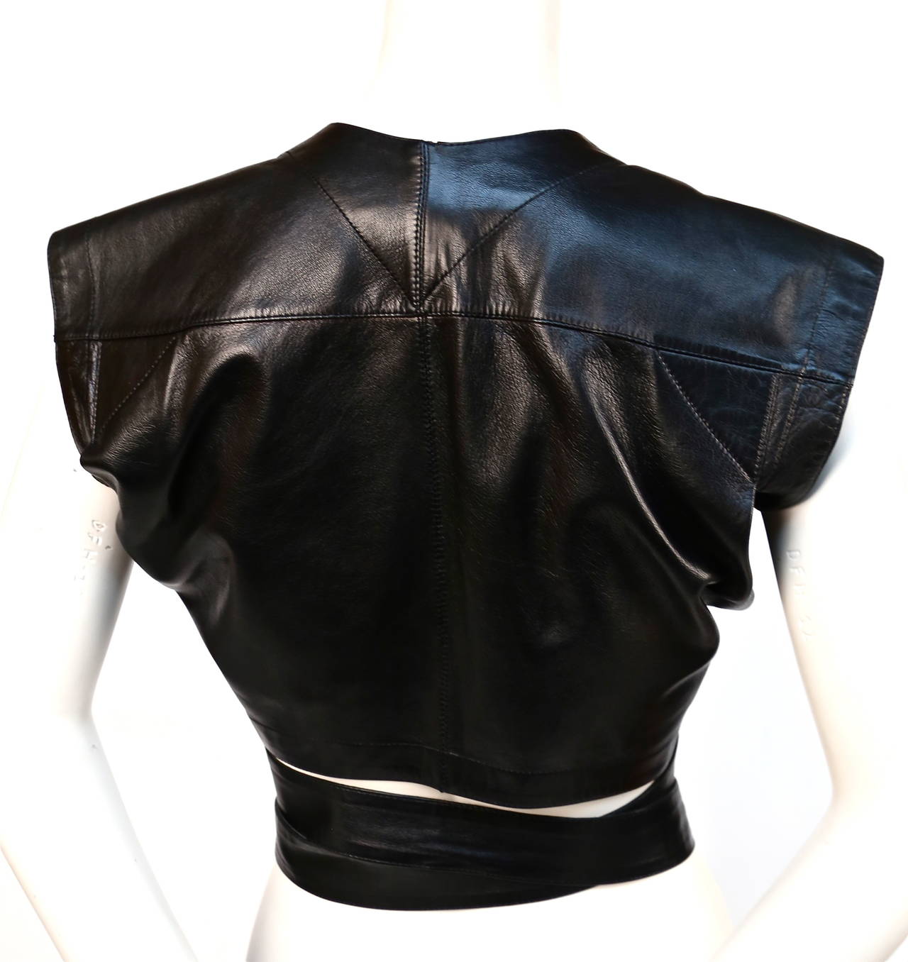 Jet black leather wrap bustier top with belt and silver buckle from Azzedine Alaia dating to the 1990's. No size is indicated however this bustier top best fits a US 4-6. It is adjustable and could probably fit a size 8 with a small waist. Very good