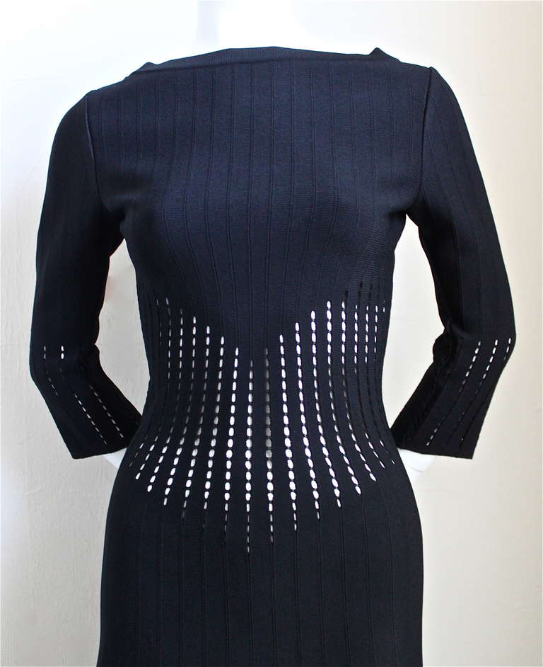 Jet black knit dress with very flattering cutout detail at waistline and arms and fringed hemline from Azzedine Alaia. Labeled a French size 40 although this dress runs small and would better suit a French 38. Approximate unstretched measurements: