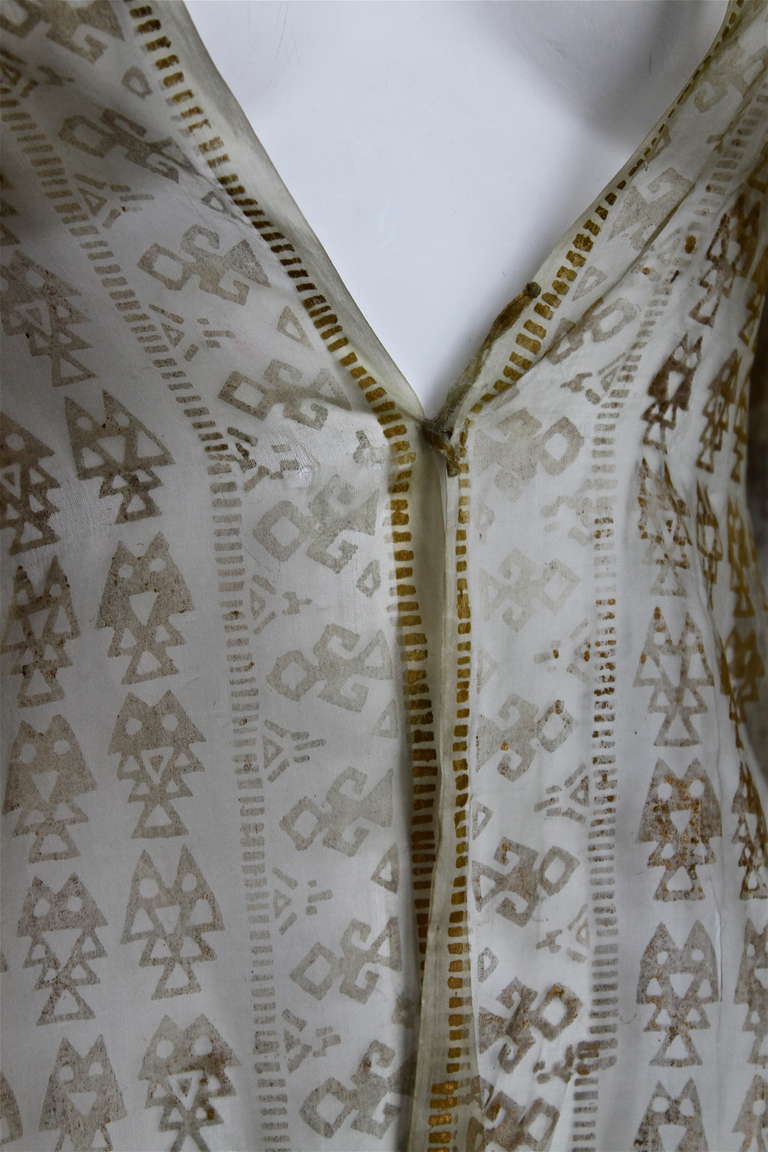 Very rare cream silk gauze jacket with gold stamping designed by Mariano Fortuny dating to ca. 1905-1919. Silk gauze jacket is printed with overall ancient Peruvian geometrical motifs and Peruvian figural borders and lines around front hem and