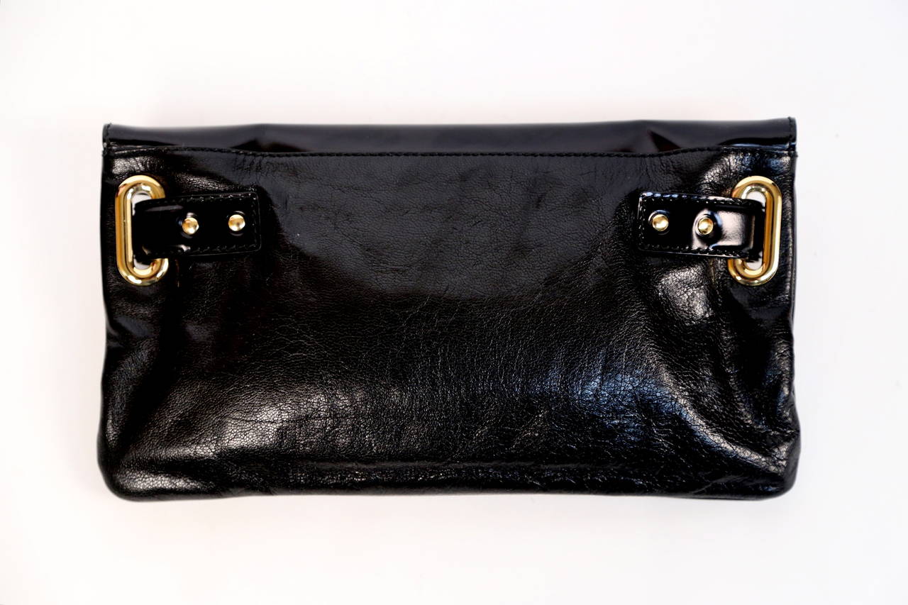 Black shiny goatskin 'Lune' bag with black patent leather details and gold toned metal hardware with twist-lock closure designed by Balenciaga dating to 2009.  Approximate measurements: 11.5