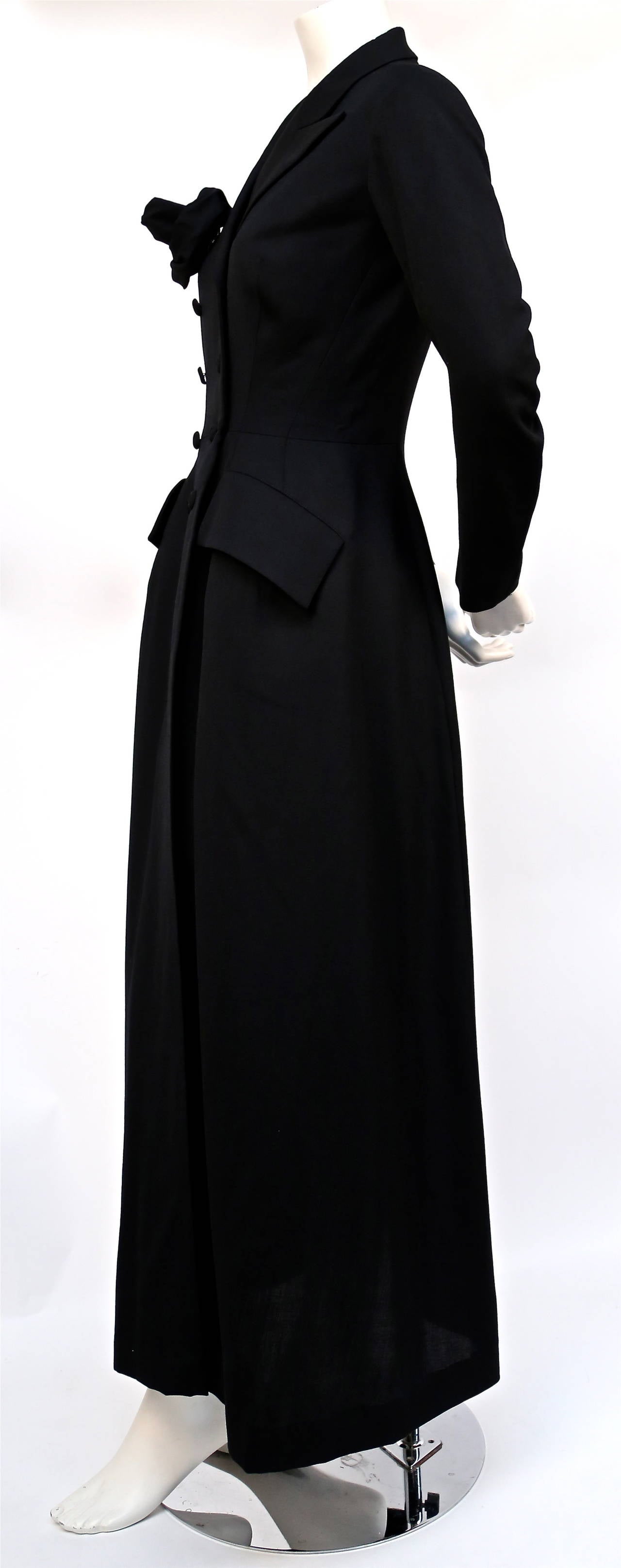 Very dramatic, jet black, floor length fitted dress coat from Yohji Yamamoto dating to the 1980's. Removable matching fabric 'rose' brooch. Labeled a size XS. Approximate measurements: shoulders 16