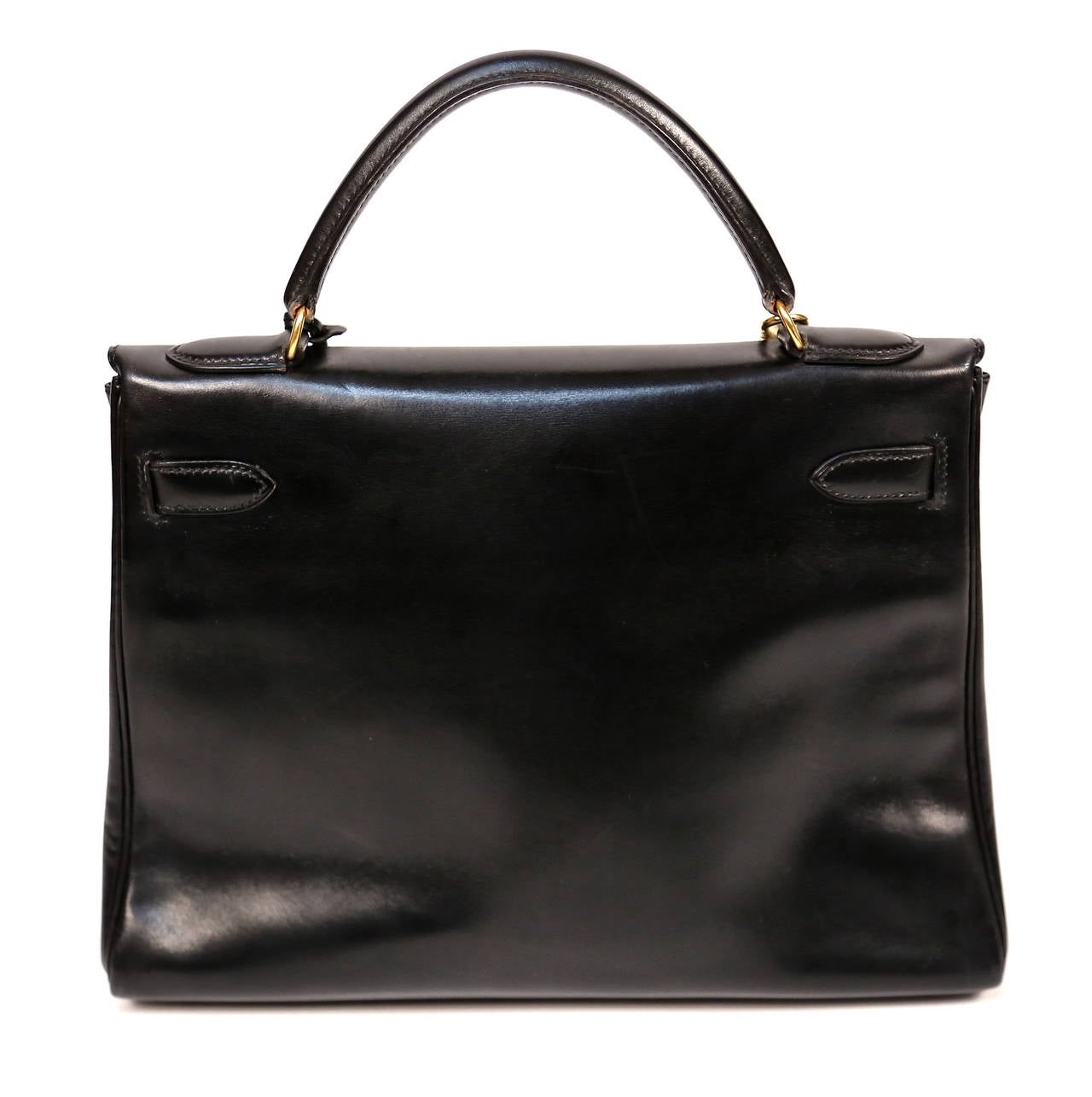 Hermes Kelly retourne bag in jet black box leather with gold hardware. 32 cm size. Blind-stamp v in a circle which corresponds to year 1992. The leather has developed a beautiful rich patina, something that is only achievable over time. A true