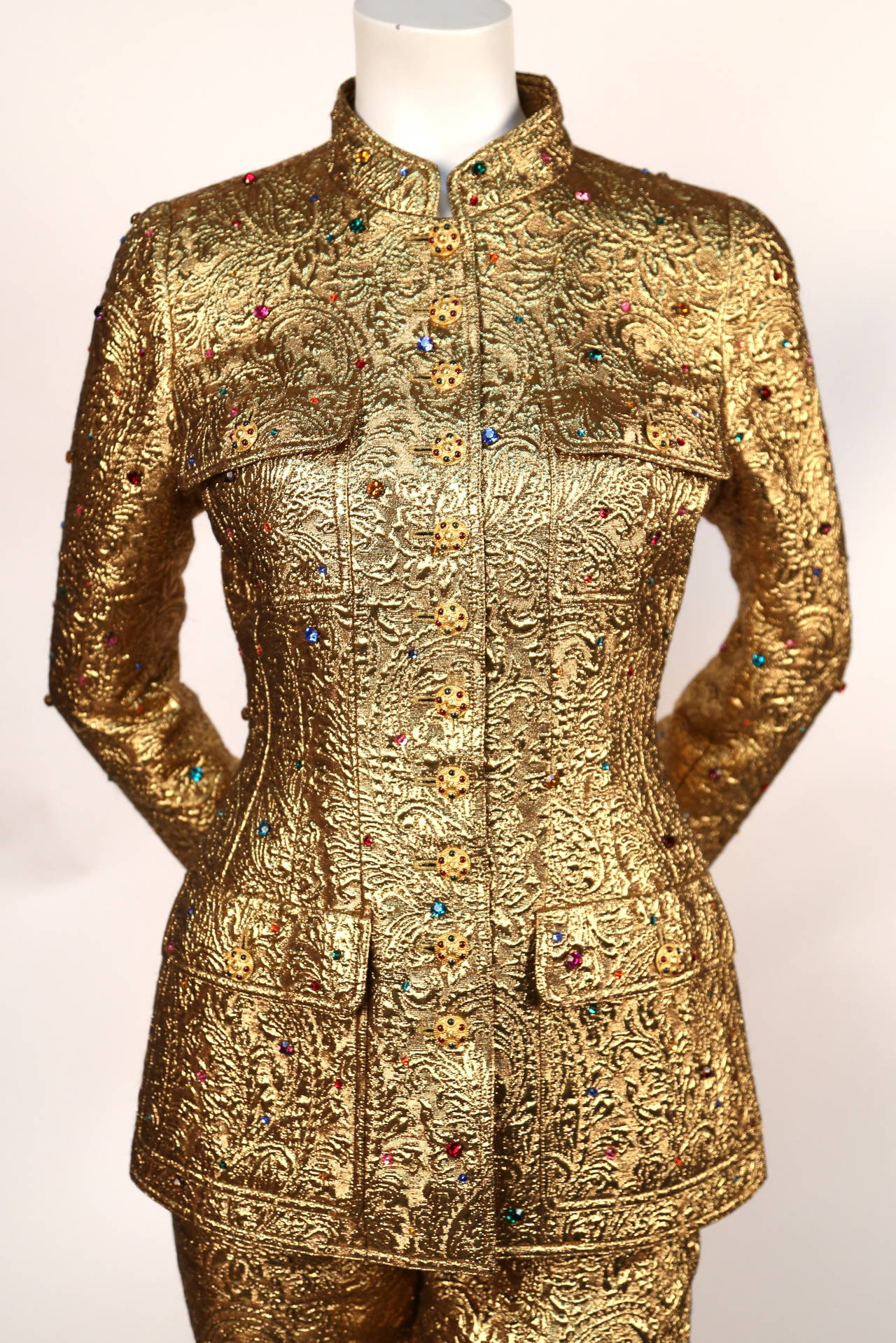 Very rare gold metallic matelasse quilted suit with colored rhinestones and poured glass Gripoix buttons from Chanel exactly as seen on the runway and featured in the Chanel ad campaign for fall of 1996. Labeled a French size 36. Approximate