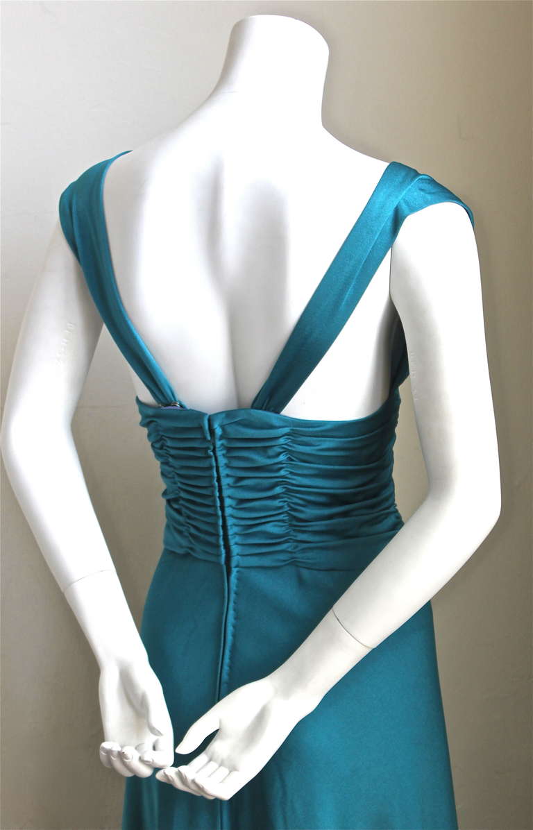 Stunning vivid turquoise blue jersey gown with rushing from Loris Azzaro dating to the 1970's. Dress best fits a size 2-4. Best fits a 32-33