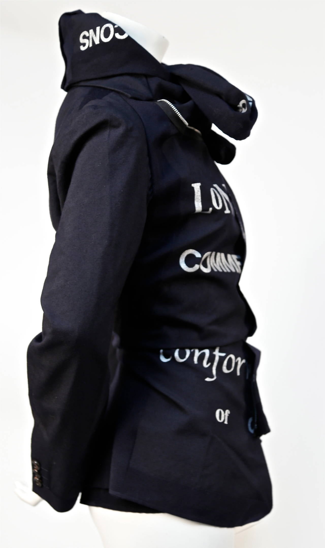 Asymmetrical woven jacket with metallic silver screen printed font from Comme Des Garcons dating to fall of 2003 as seen on the runway. Color is a deepest navy/black. Labeled a size 'M' however this jacket best fits a size XS or S (26