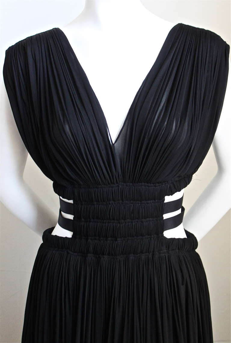 Jet black semi sheer ruched dress with cutout sides and elastic bands from Azzedine Alaia. Dress is labeled a French size 36 and best fits someone with a waist of 24-26