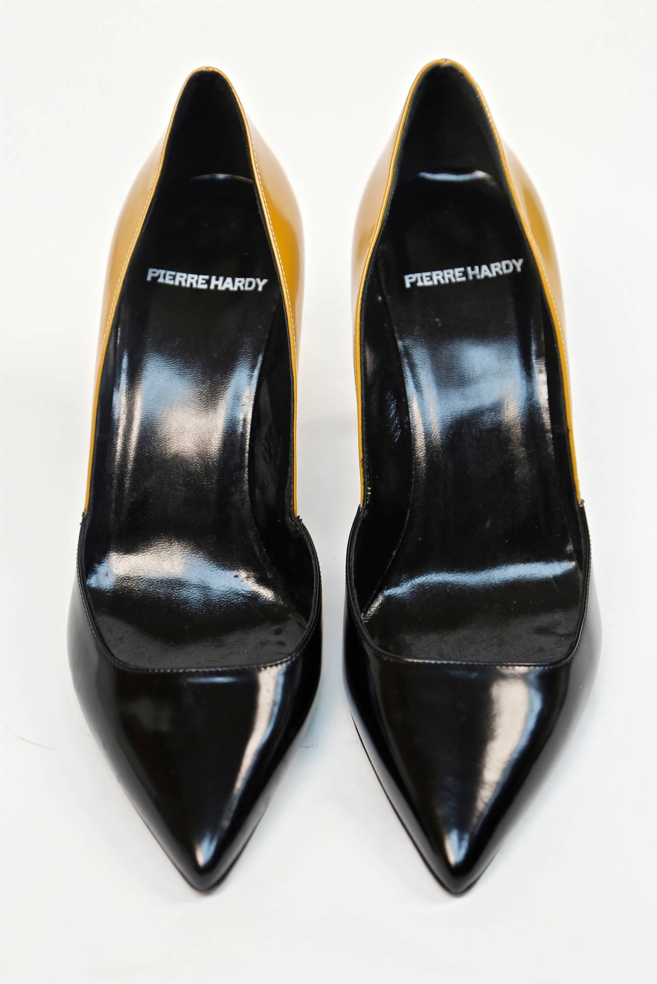 Striking pair of mustard yellow and black polished leather heels designed by Pierre Hardy. French size 38 which fits a US 7 or 7.5. Heels measure approximately 3.5