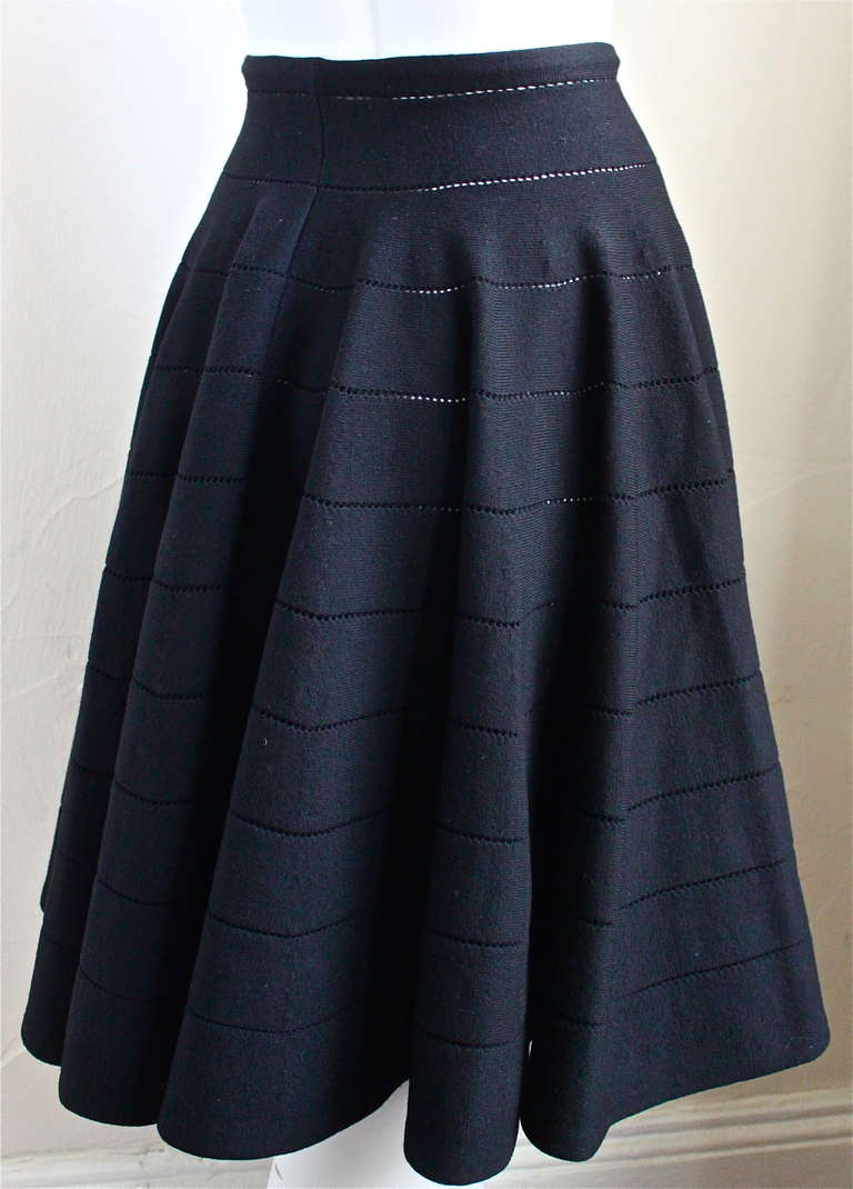 Jet black wool blend pointelle knit skirt from Azzedine Alaia. Labeled a size 'XS'. Can fit up to a size S due to stretch.  Unstretched measurements are: waist 22