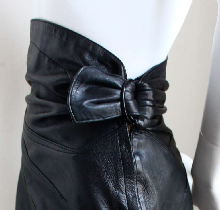Jet black butter soft lambskin leather skirt with ruching, top-stitching and antiqued brass buckle detail from Azzedine Alaia dating to the early 1990's. Labeled a French size 40 however this skirt best fits a U.S. size 6. Approximate measurements: