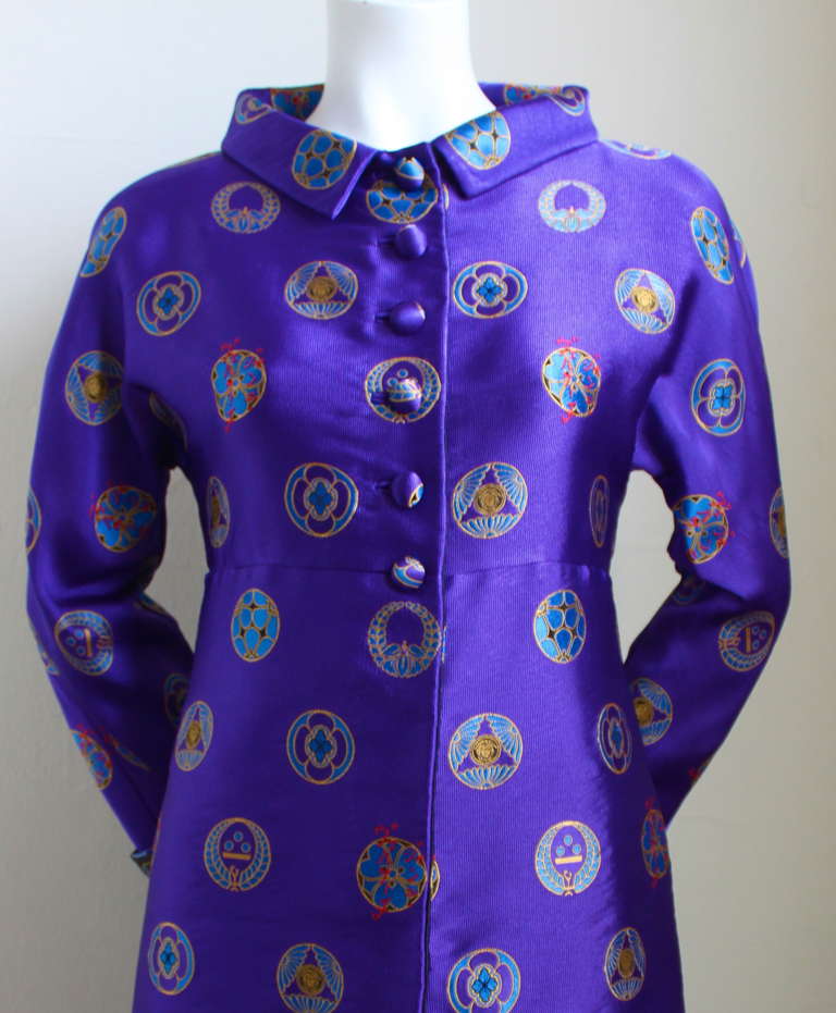 Rich purple silk brocade coat with Asian motif and Medusa medallions from Versace Atelier dating to 1993. Impeccable quality throughout. Coat is lined in contrasting black fabric and looks just as beautiful on the inside as it does on its exterior.