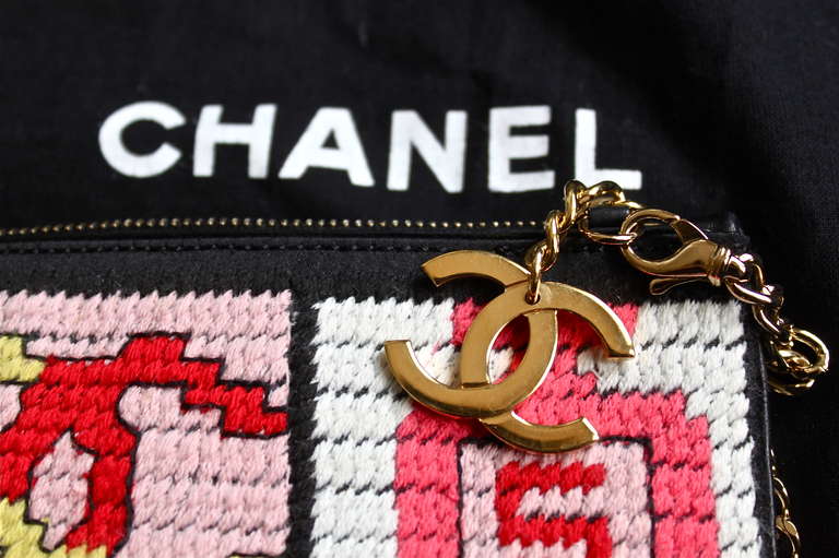 Needlepoint bag with lucky symbols motif from Chanel.  Symbols include: a bow, interlocking CC logo, Chanel No. 5 perfume bottle, a # 5, and a shamrock. Great as an evening bag. Bag measures approximately 8.5