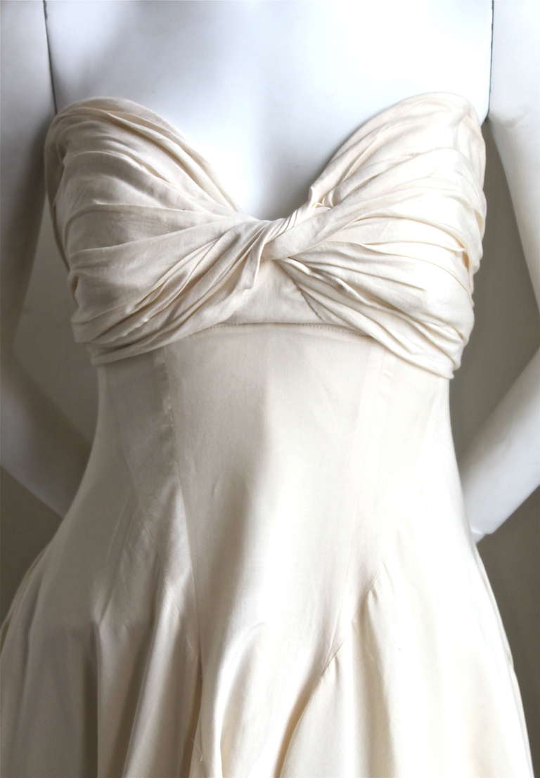 Very unique cream cotton strapless dress with shirring at bust and asymmetrical hemline from Yohji Yamamoto dating to the 1990's. Labeled a Japanese size 2. Best fits a bust of 33-34