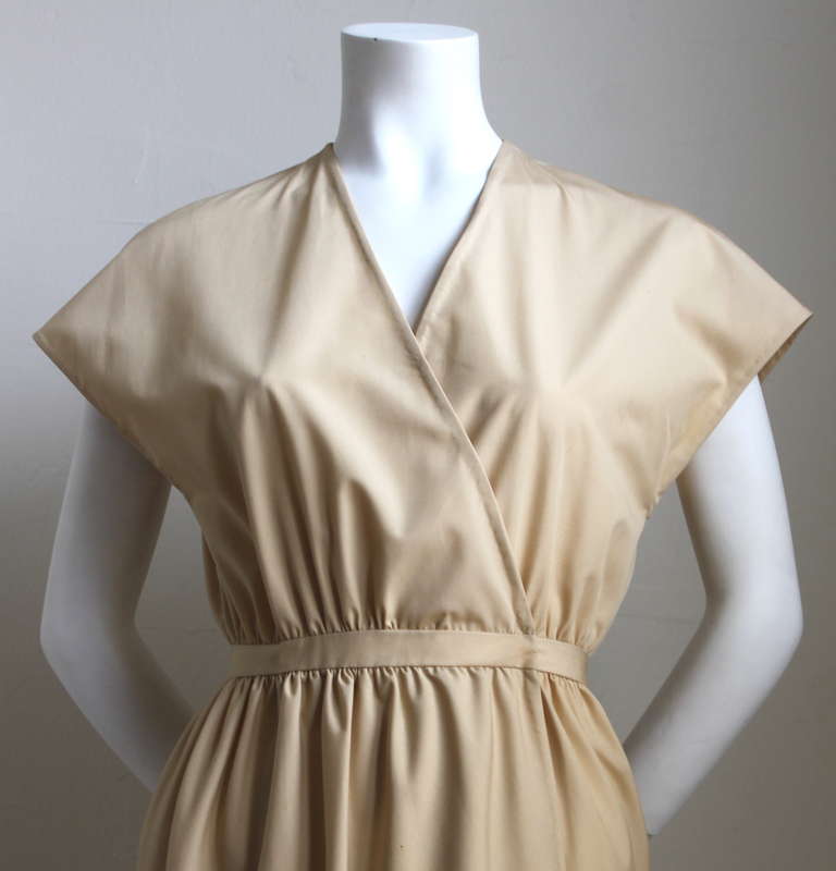 Classic minimalist tan tulip wrap dress from Halston dating to the 1970's. Dress is labeled a US 4 but best fits a US size 2. Approximate measurements: bust 32