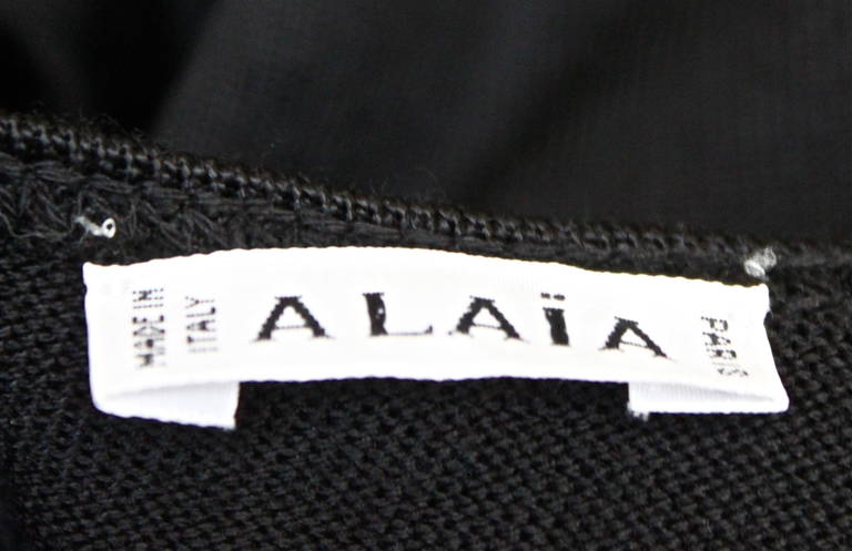 Classic jet black seamed mini dress with open back and flared skirt by Azzedine Alaia dating to the 1990's. Dress is labeled an XS. Dress zips up back at center hips to waistline and secures with a hook/eye. Made in Italy. Excellent condition.