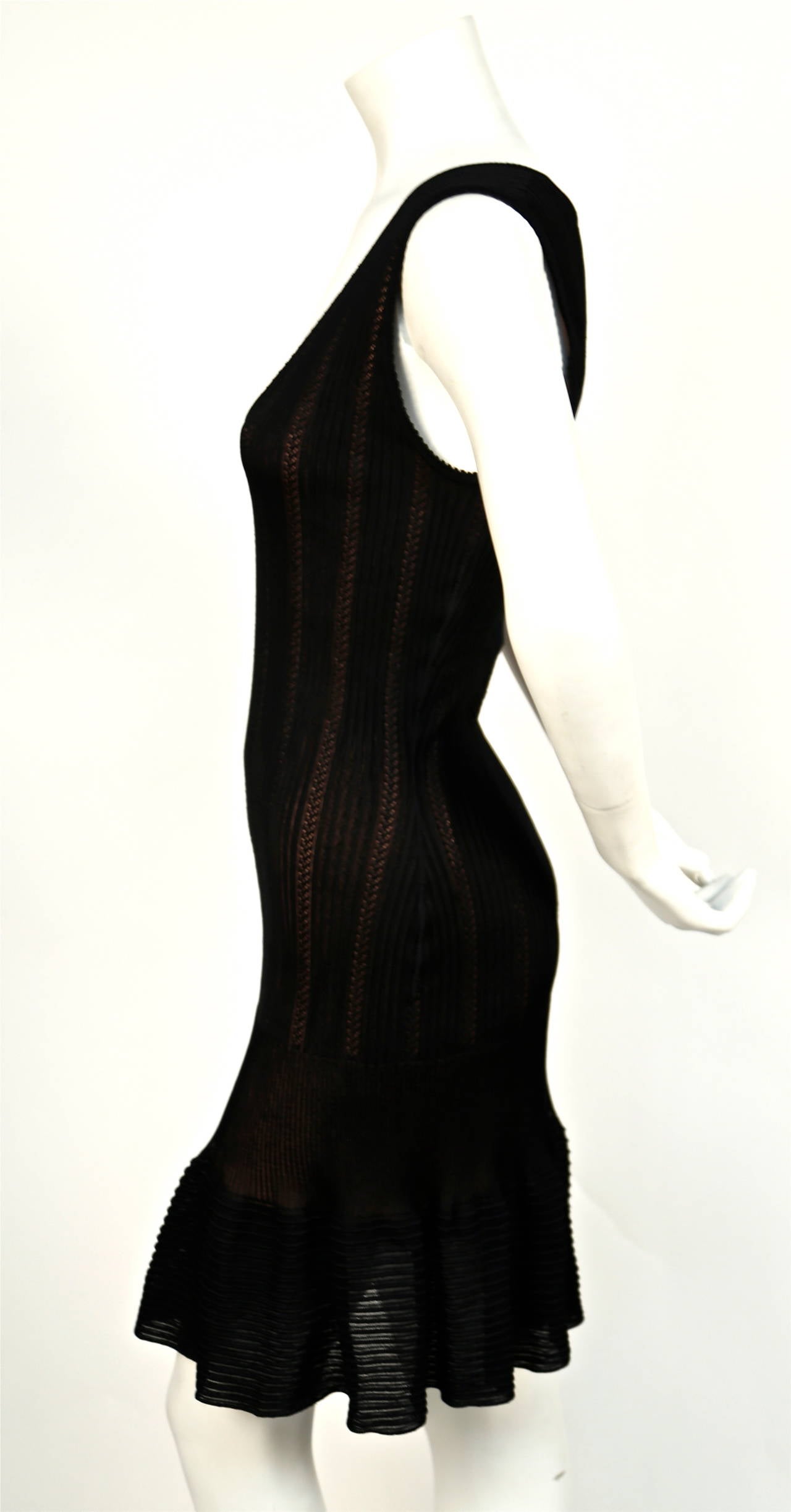 Jet black semi sheer pointelle knit dress with nude lining and deep V neckline designed by Azzedine Alaia dating to the early 1990's. Dress best fits a size S or M. Approximate measurements are as follows: bust 32