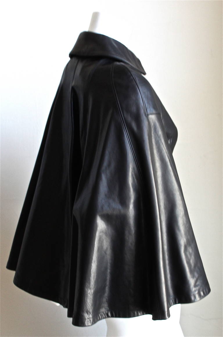 Very unusual, jet black leather cape jacket from Junya Watanabe for Comme Des Garcons exactly as seen on the runway for fall of 2011. Labeled a size XS, which best fits a US 2 (up to 32