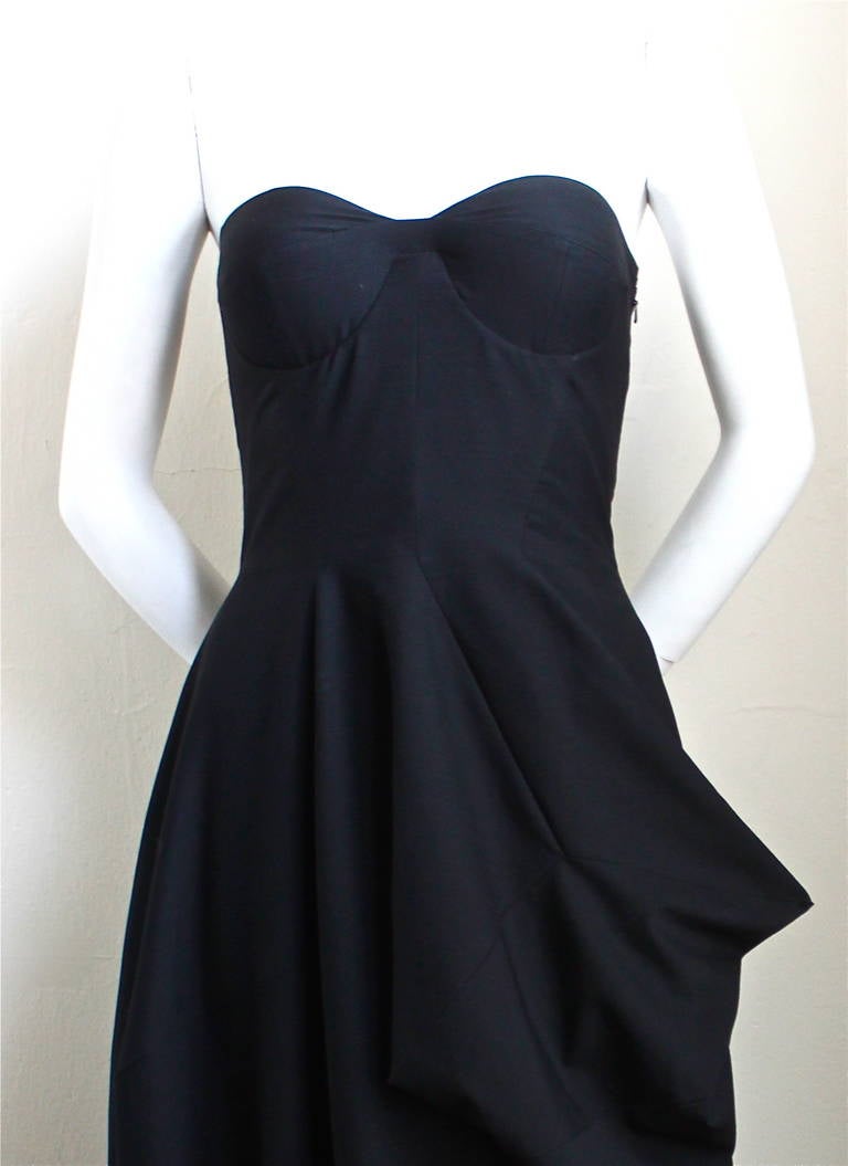 Very rare black strapless bustier dress with very unique seaming and draped side detail designed by Raf Simons for Jil Sander exactly as seen on the runway for fall 2012. Finale piece. German size 34 which fits a US 2. Approximate measurements: bust