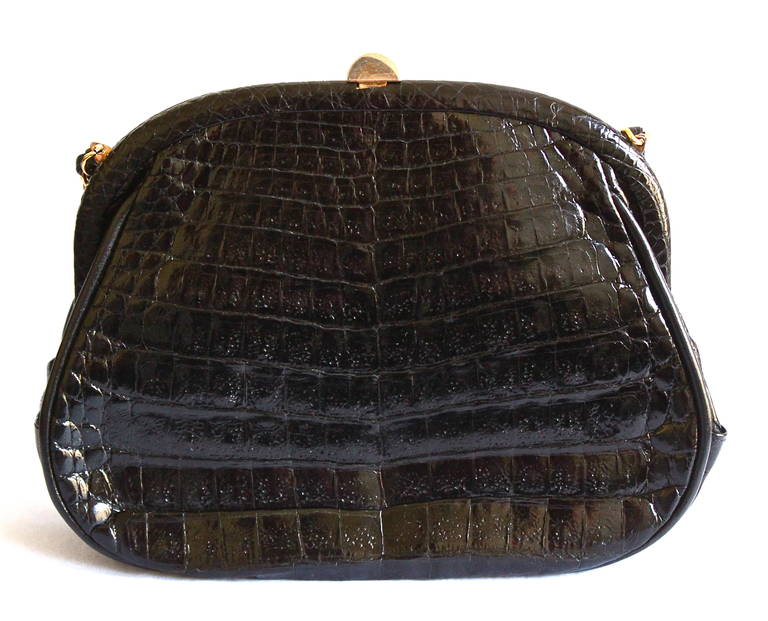 Jet black crocodile convertible clutch with hidden woven gilt cross by strap by Chanel dating to the 1980's. Approximate measurements: just over 9