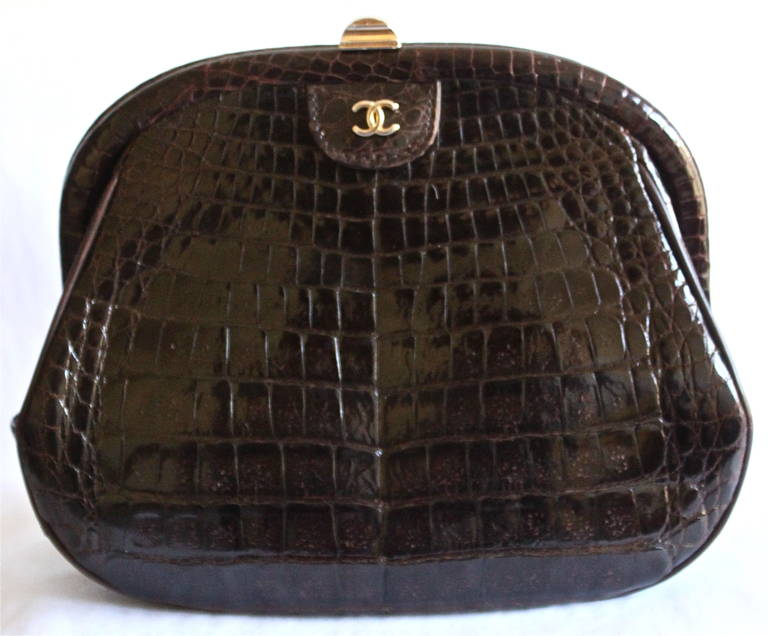 Deep brown crocodile convertible clutch with hidden woven gilt shoulder strap by Chanel dating to the 1980's. Approximate measurements: just over 9