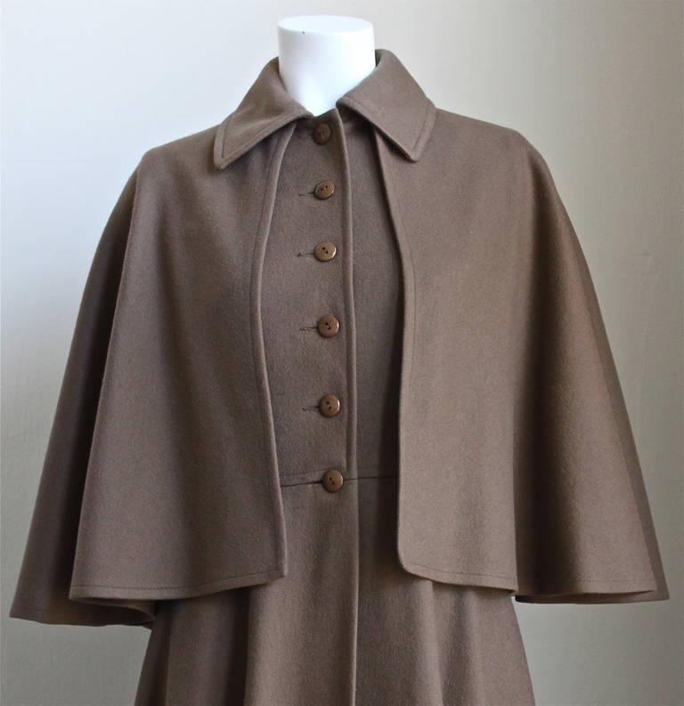 Dark taupe brown fitted long coat with capelet from Yves Saint Laurent dating to the 1970. Exact version as seen on Francoise Hardy. Labeled a French size 38 however this coat is quite small and better suits a FR 36. Approximate measurements: