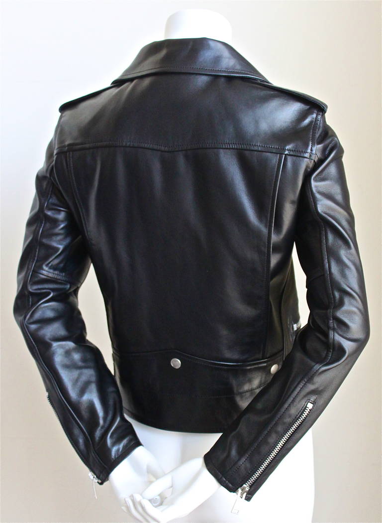 Jet black butter soft leather biker jacket with silver hardware by Hedi Slimane for Saint Laurent dating to fall of 2013. French size 40 (runs small). Approximate measurements: shoulder 15
