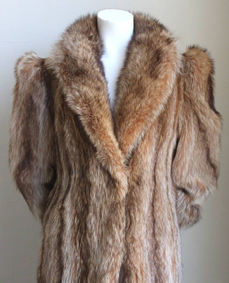 Full length Tanuki Raccoon fur coat with interesting striped detail at lower arms dating to the late 1970's, early 1980's. Coat best fits a US size 8-10 for a tall woman. Approximate measurements: shoulders 14