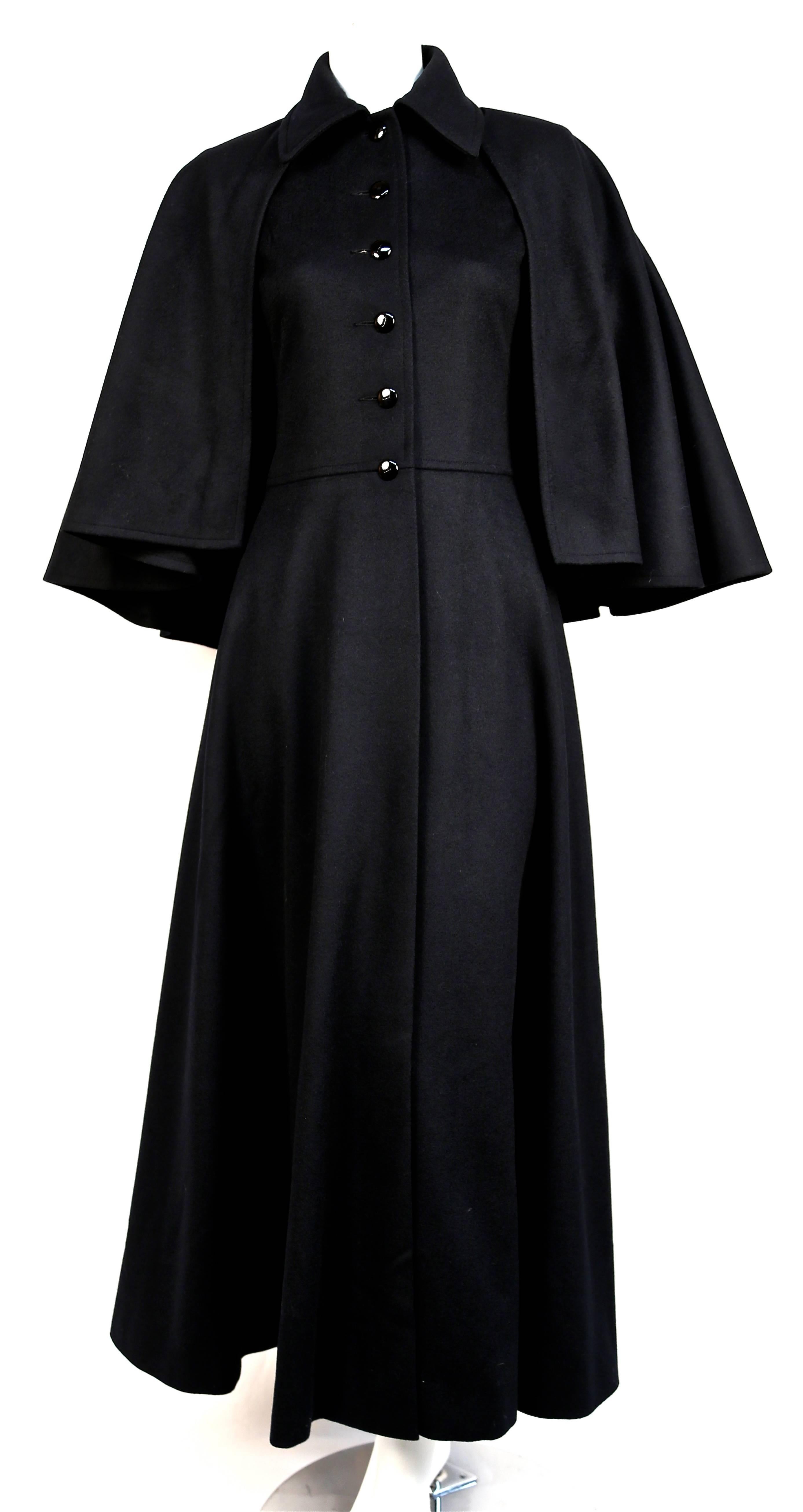 Jet black fitted long wool coat with removable capelet from Yves Saint Laurent dating to the 1970. Exact version as seen on Francoise Hardy. Labeled a French size 40 however this coat is quite small and better suits a FR 38. Approximate