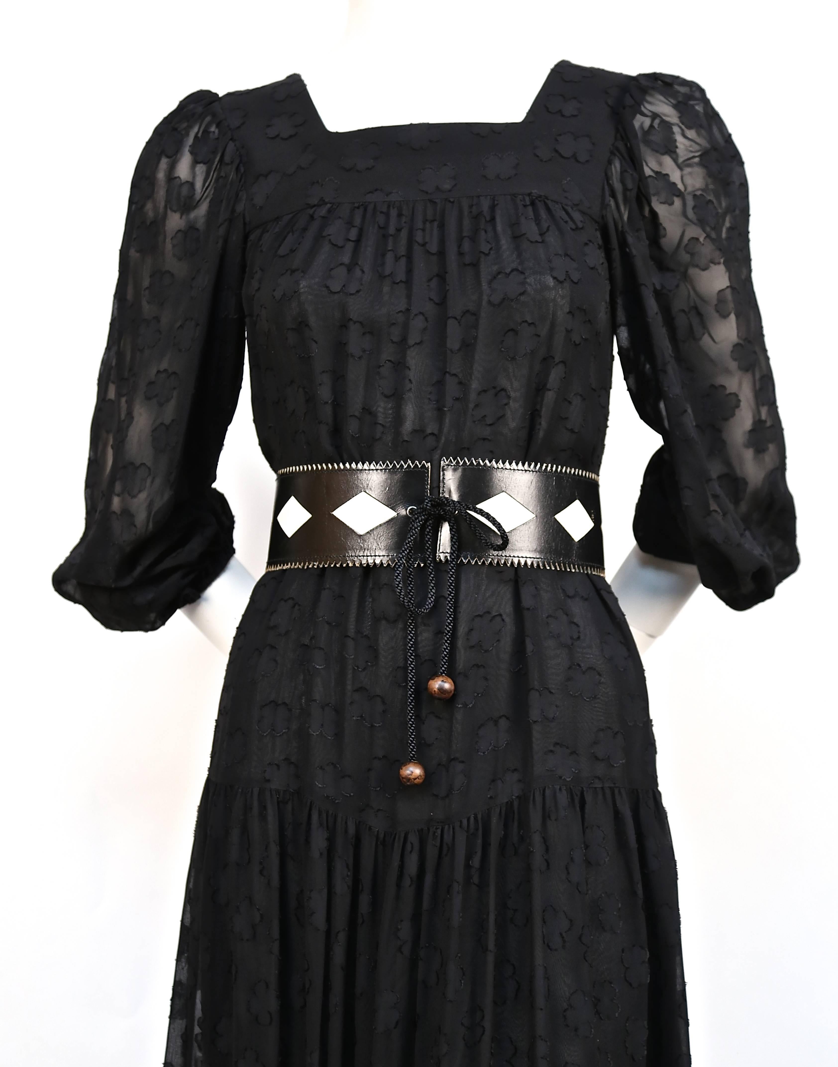 Black peasant dress with woven abstract floral pattern from Yves Saint Laurent dating to the 1970's. Best fits a French 34 or 36. Approximate measurements: shoulder 13", underarm to underarm 30", bust 32", hips 42" and length