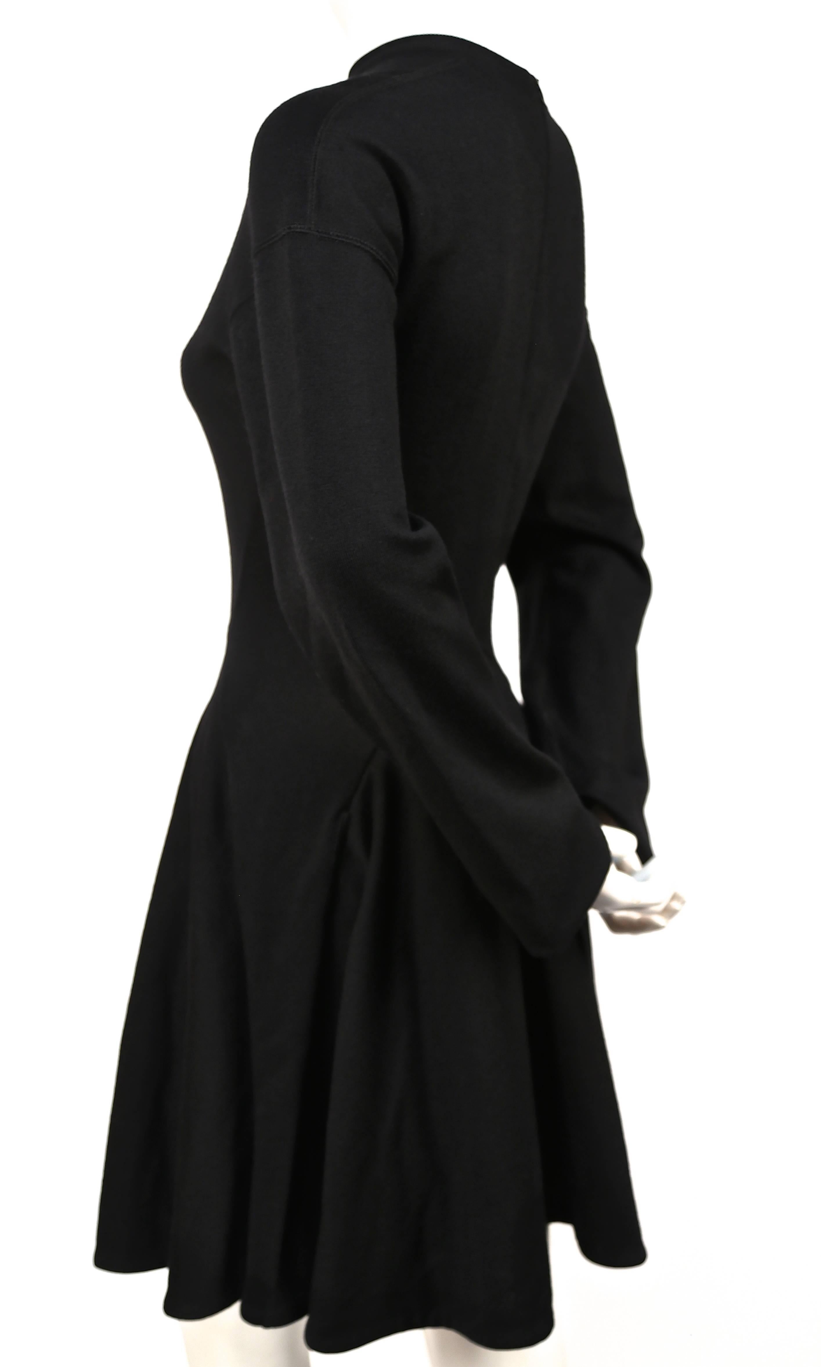 Incredibly flattering jet black seamed wool-dress with full skirt from Azzedine Alaia dating to the 1990's. Fits a size S or M.  Unstretched waist measures 26
