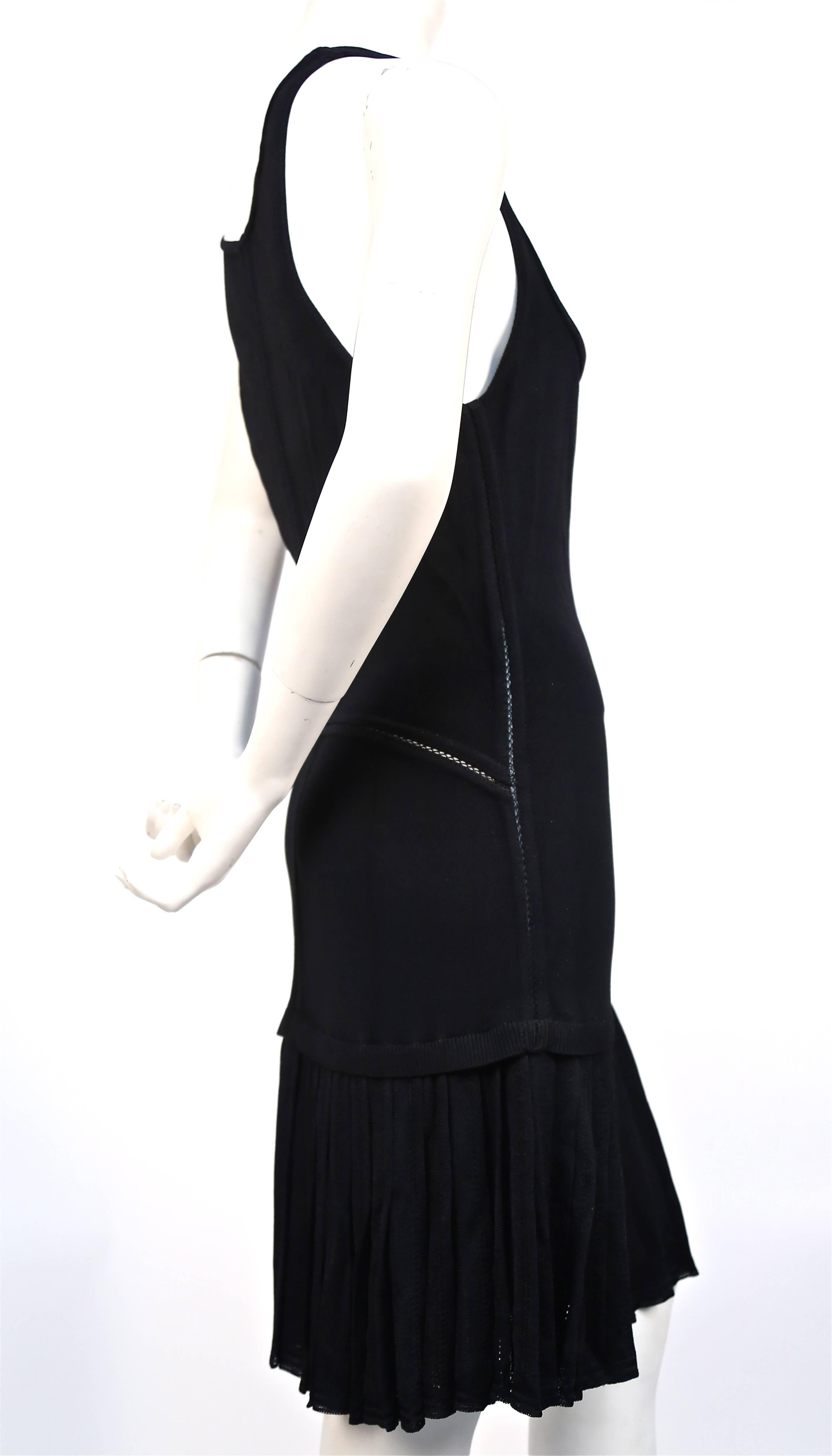 Black knit dress with drop waist and pleated skirt from Azzedine Alaia dating to the 1990's. Labeled a size 'M'. Approximate un-stretched measurements laying flat: bust 33-34